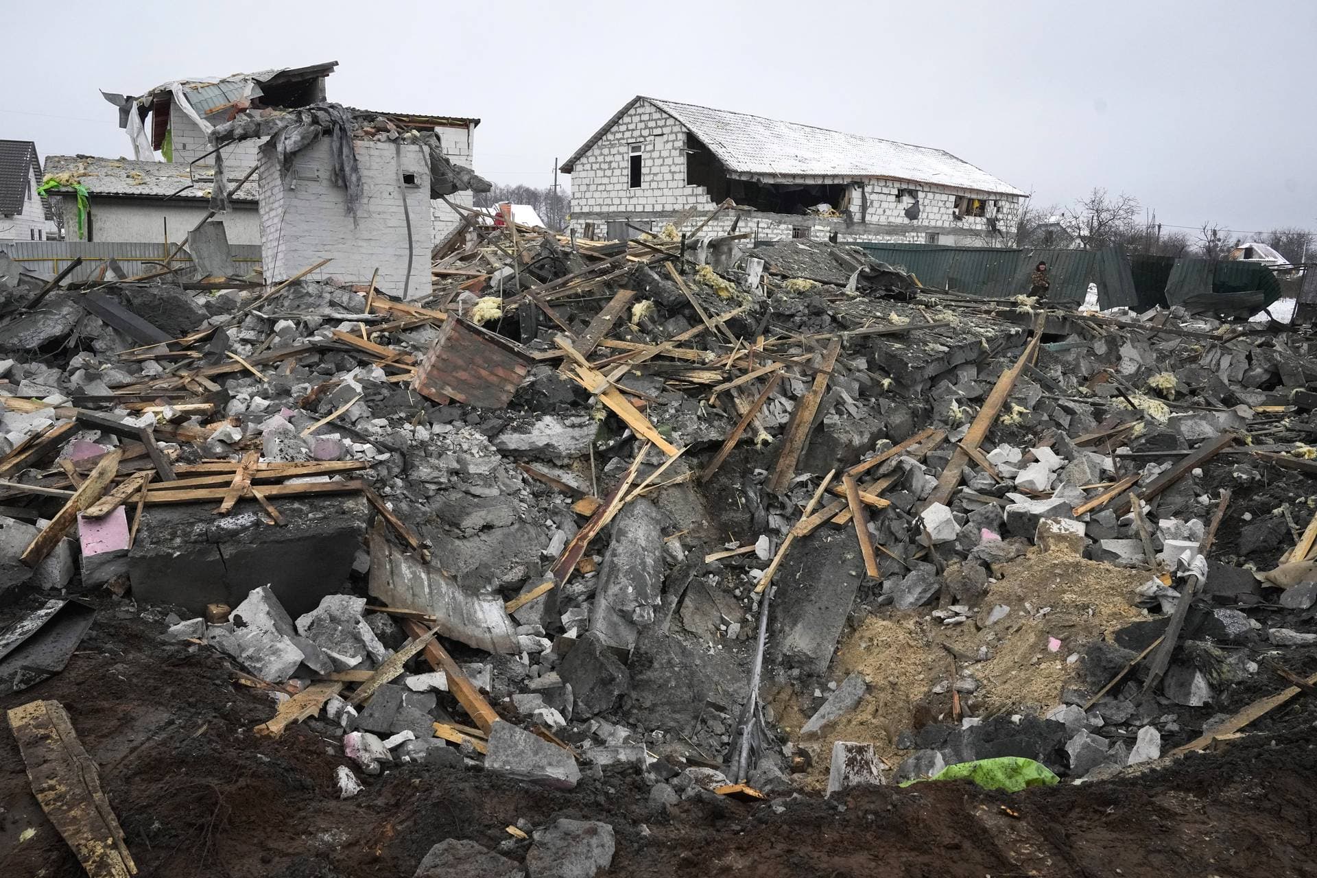 A local resident looks on the debris at a site of a recent Russian missile attack in Kyiv