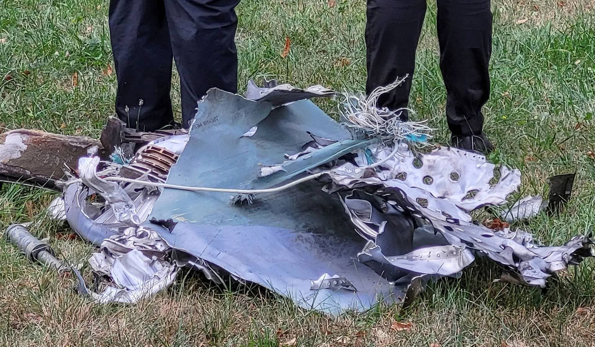 Police officers stand next to a part of a missile that landed at a park during a Russian strike in Kyiv