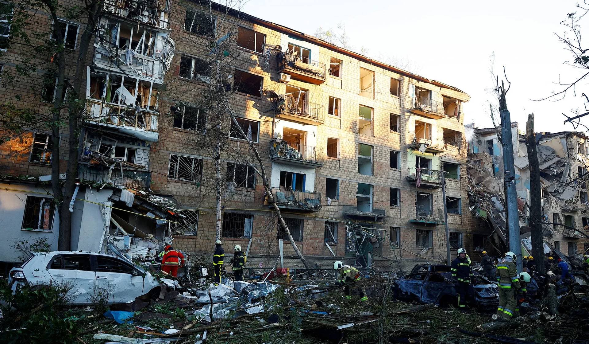 Firefighters work at the site of an apartment building hit during Russian drone and missile strikes in Kyiv