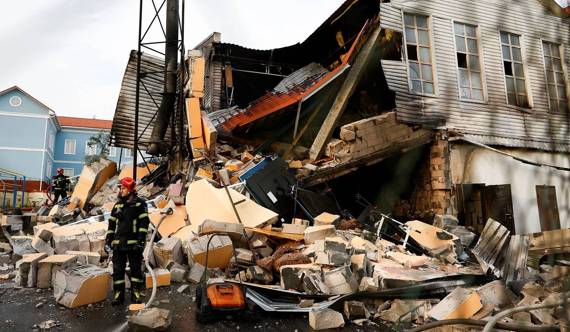 Firefighters work at a university sports complex damaged during a Russian missile strike in Kyiv
