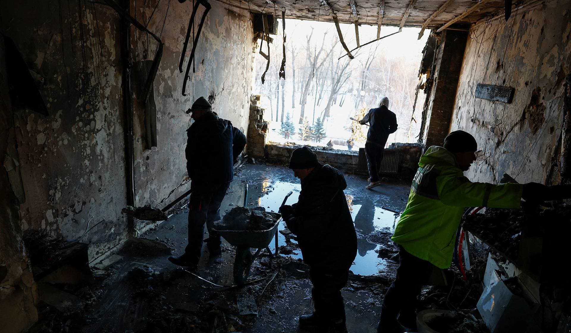 Employees remove debris at the site of a private hospital hit by Russian drone strikes in Kyiv