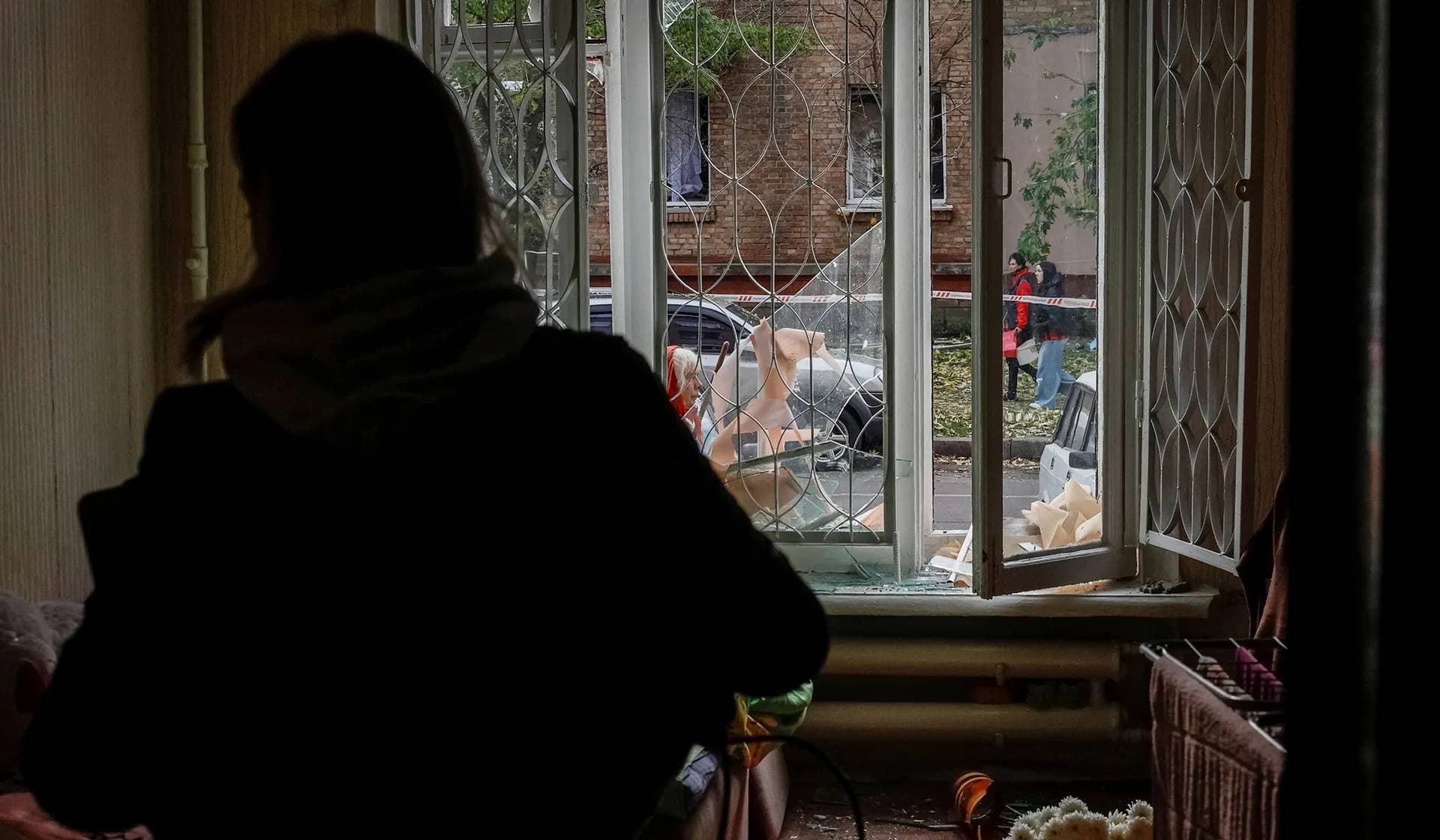 Yaroslava cleans up in her room in a residential building damaged during a Russian drone and missile strike in Kyiv