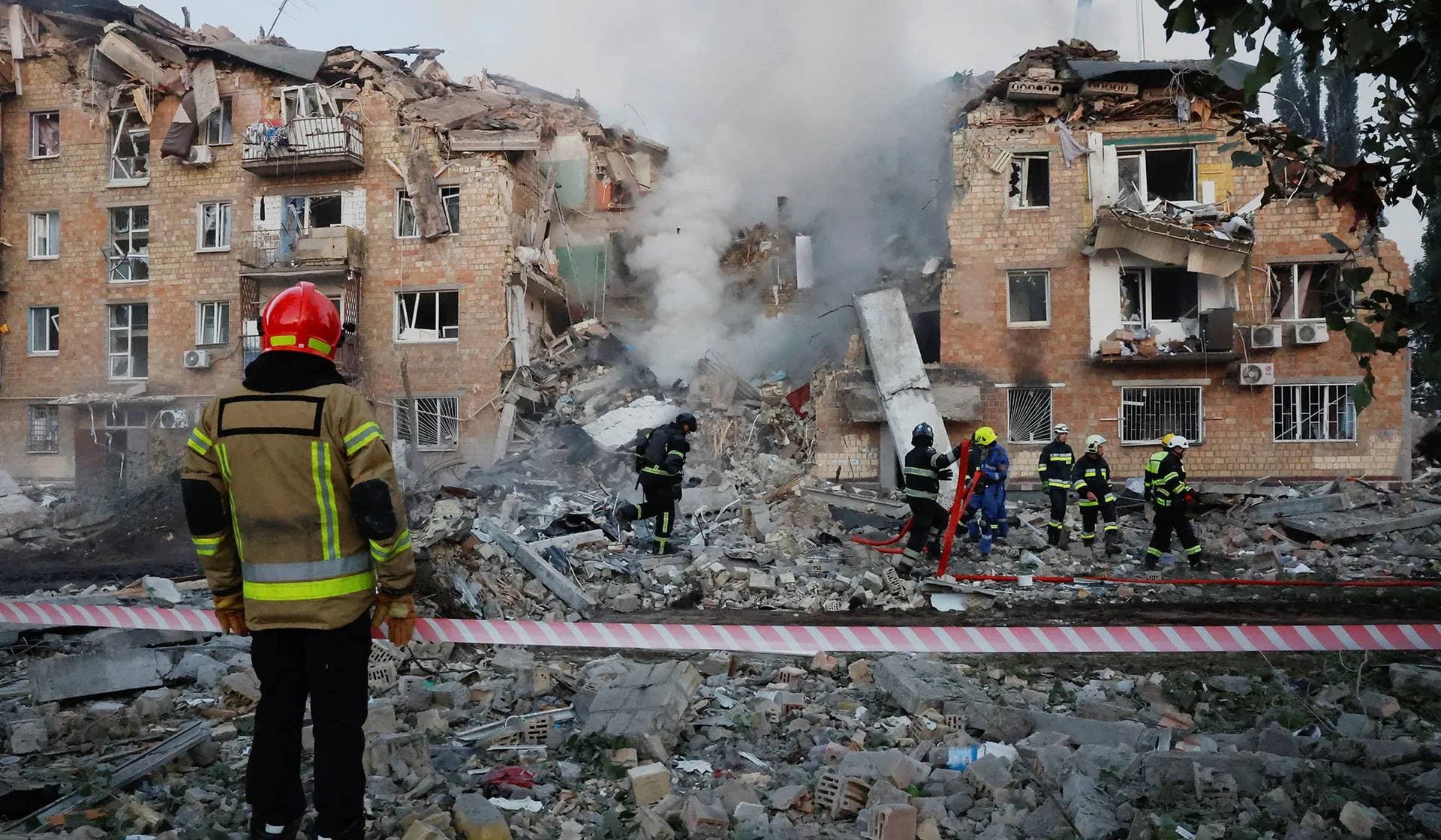 Rescuers work at the site of an apartment building which was hit by Russian missile and drone strikes in Kyiv