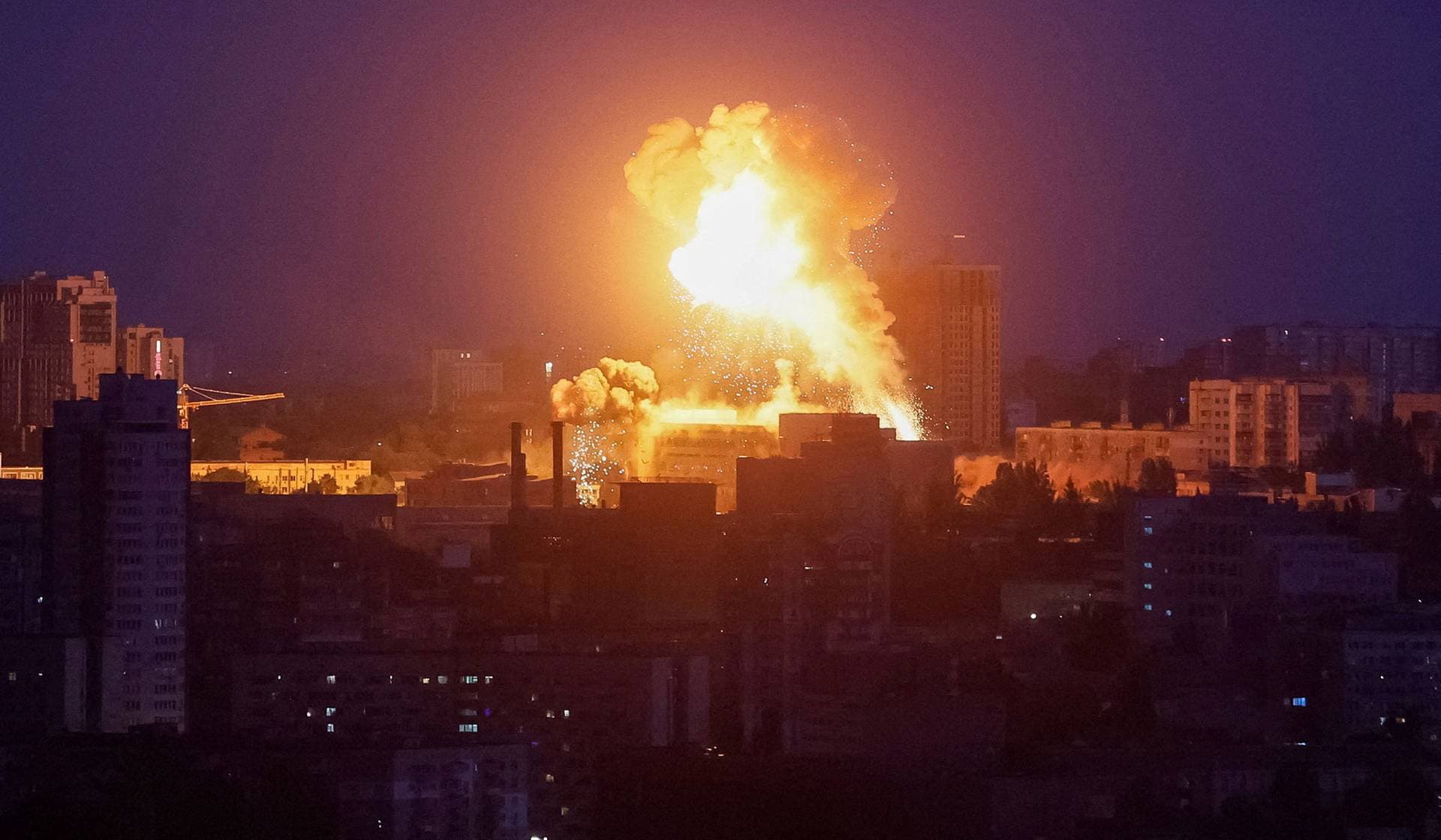 An explosion lights up the sky over the city during a Russian missile and drone strike in Kyiv