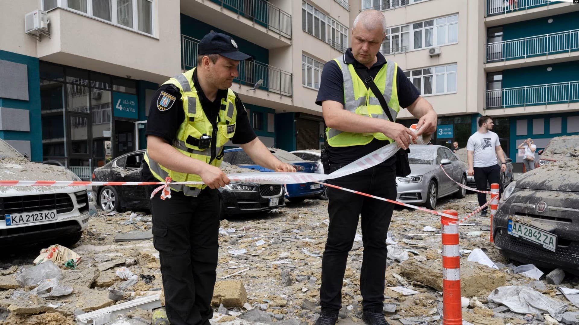 Police officers cordon off an area next to an apartment building damaged by a Russian attack in Kyiv