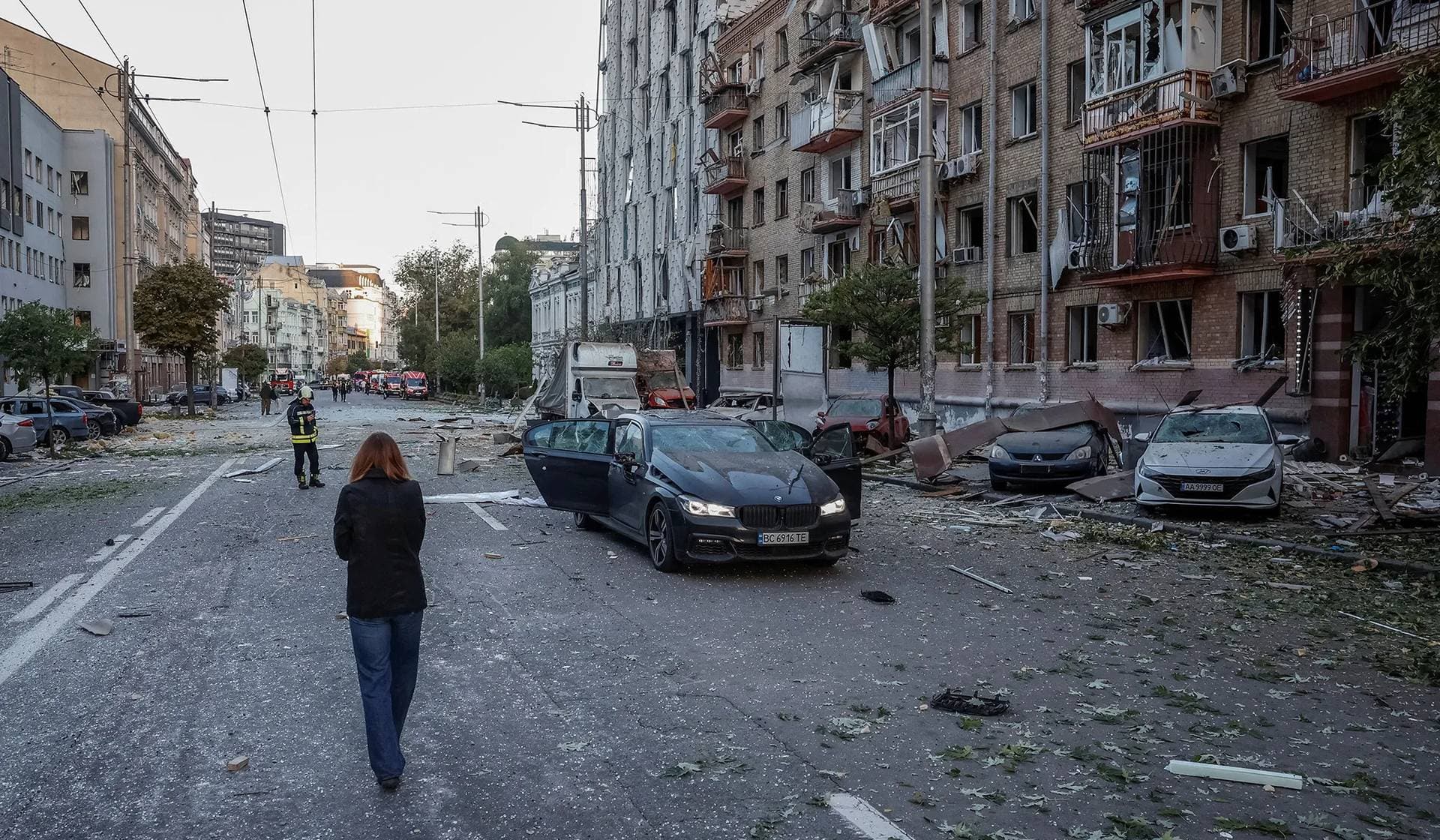 People walk at the site of buildings hit by Russian missile and drone strikes in Kyiv