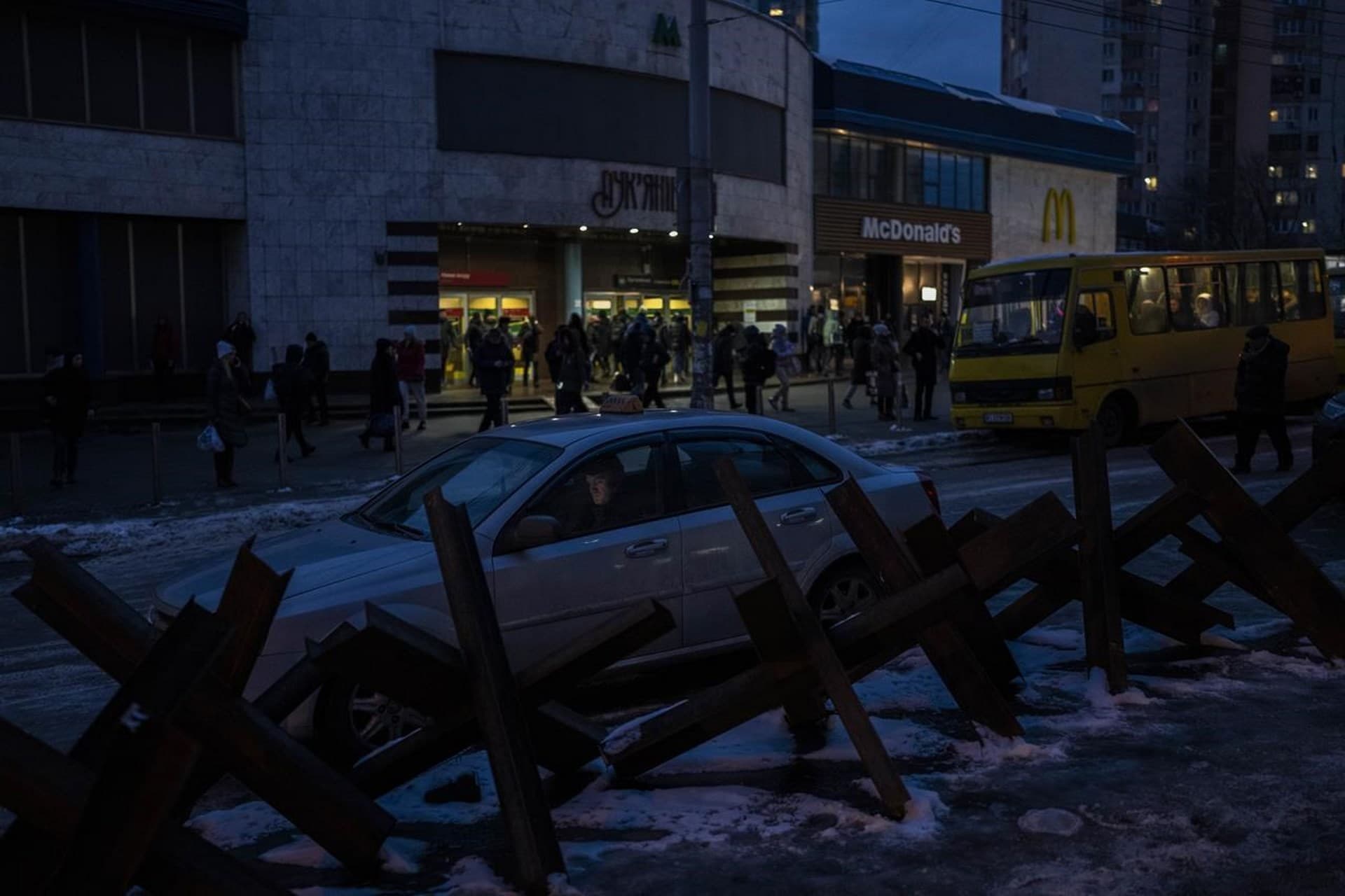 A taxi driver parks next to anti-tank hedgehogs in Kyiv