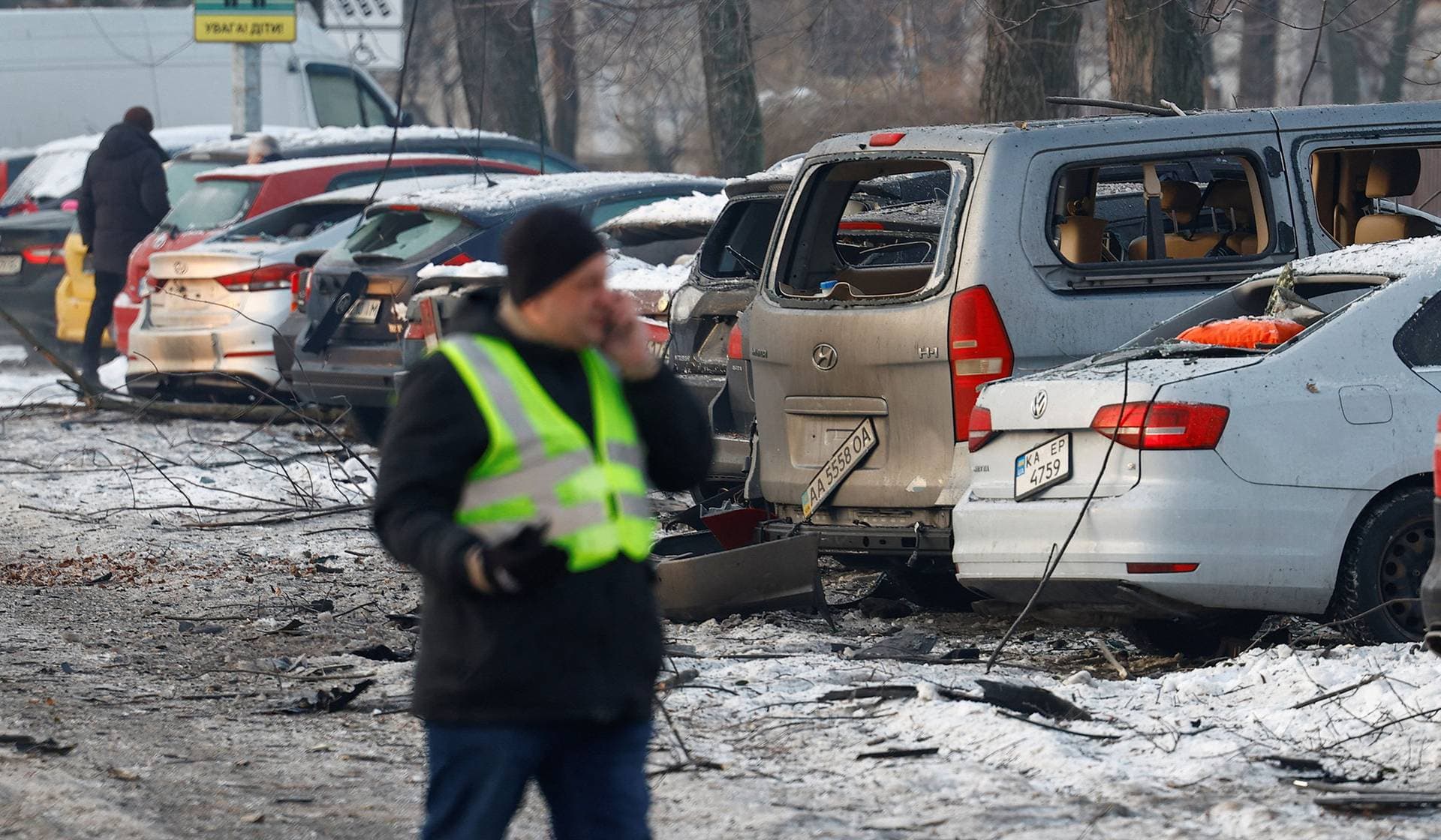 A police officer walks along cars damaged during a Russian drone strike in Kyiv