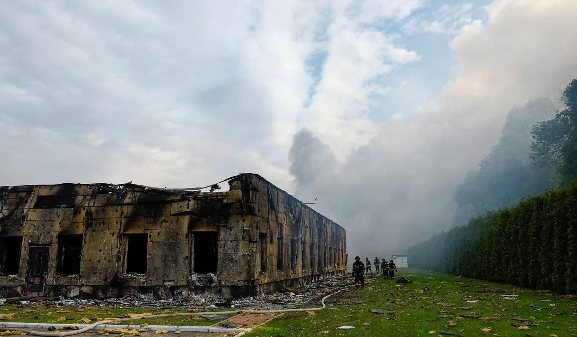 Firefighters work at the site of a private enterprise hit by a Russian drone strike outside of Kyiv
