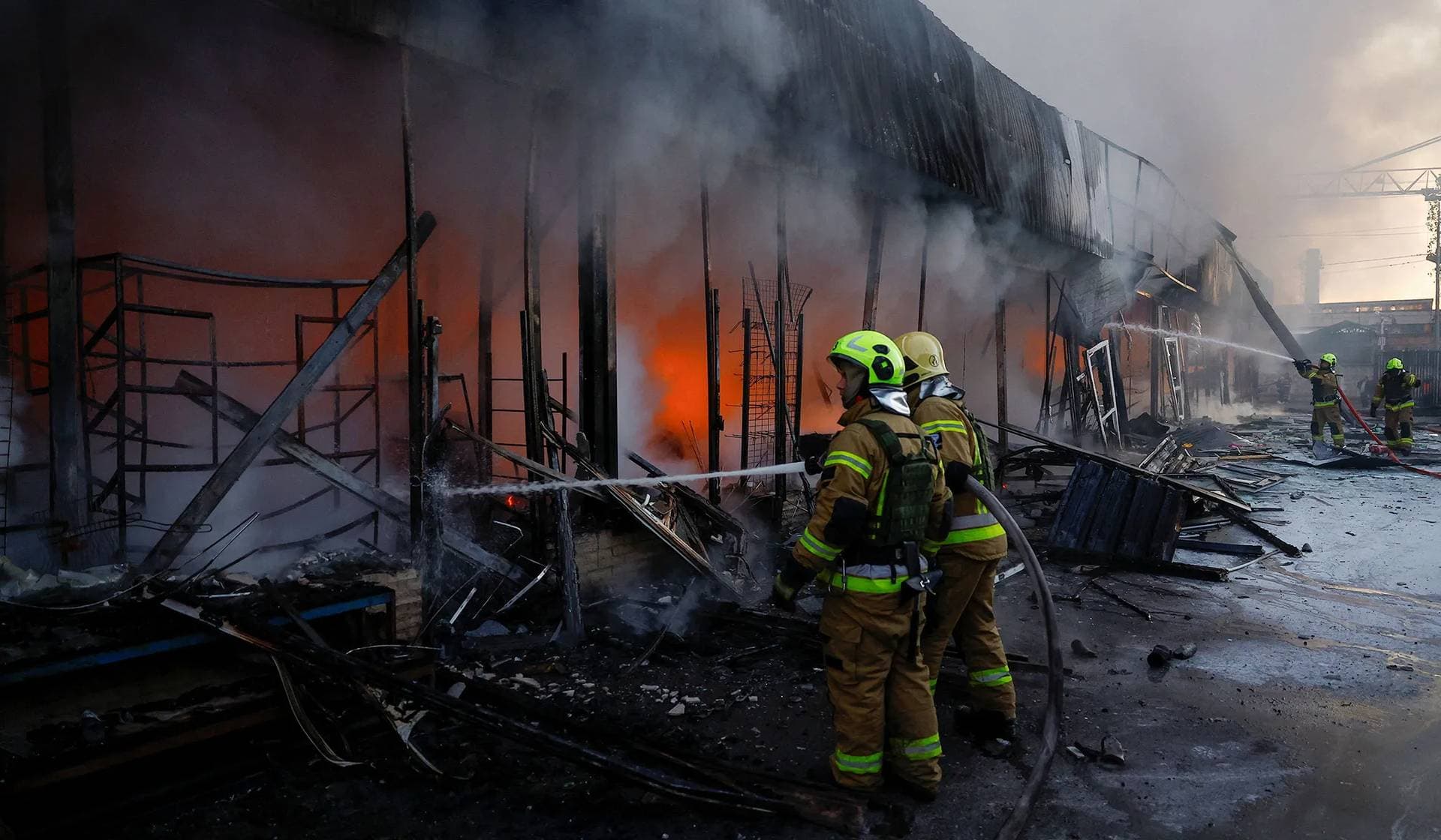 Firefighters work at the compound of a vegetable warehouse hit by a Russian drone strike in Kyiv
