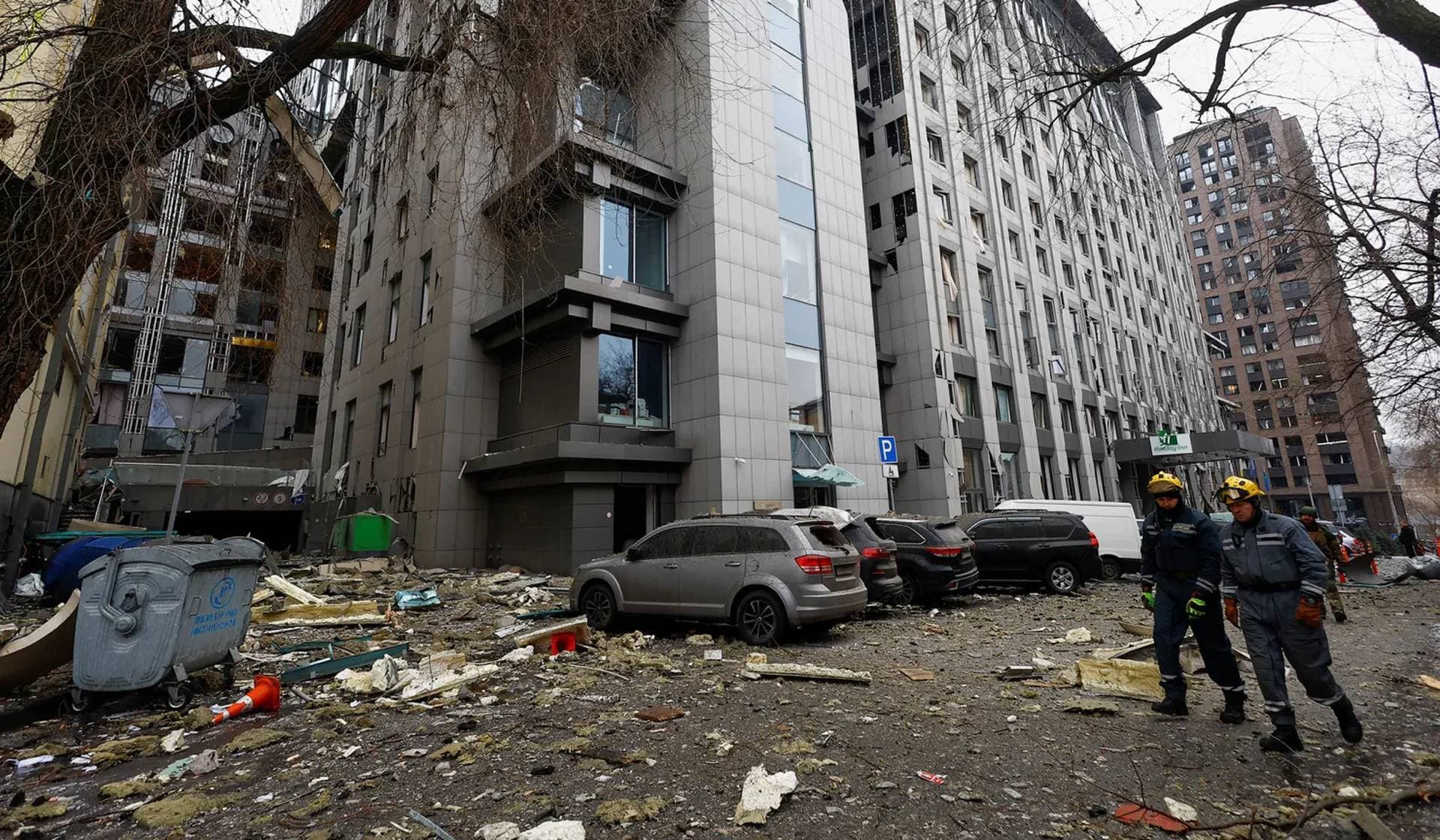 Rescuers walks near a building damaged during a Russian missile strike in central Kyiv