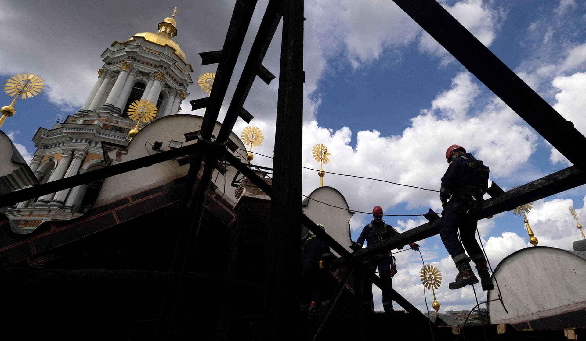 Workers repair the roof of the Dormition Cathedral of the Kyiv Pechersk Lavra after it was hit during Russian missile and drone strikes in Kyiv