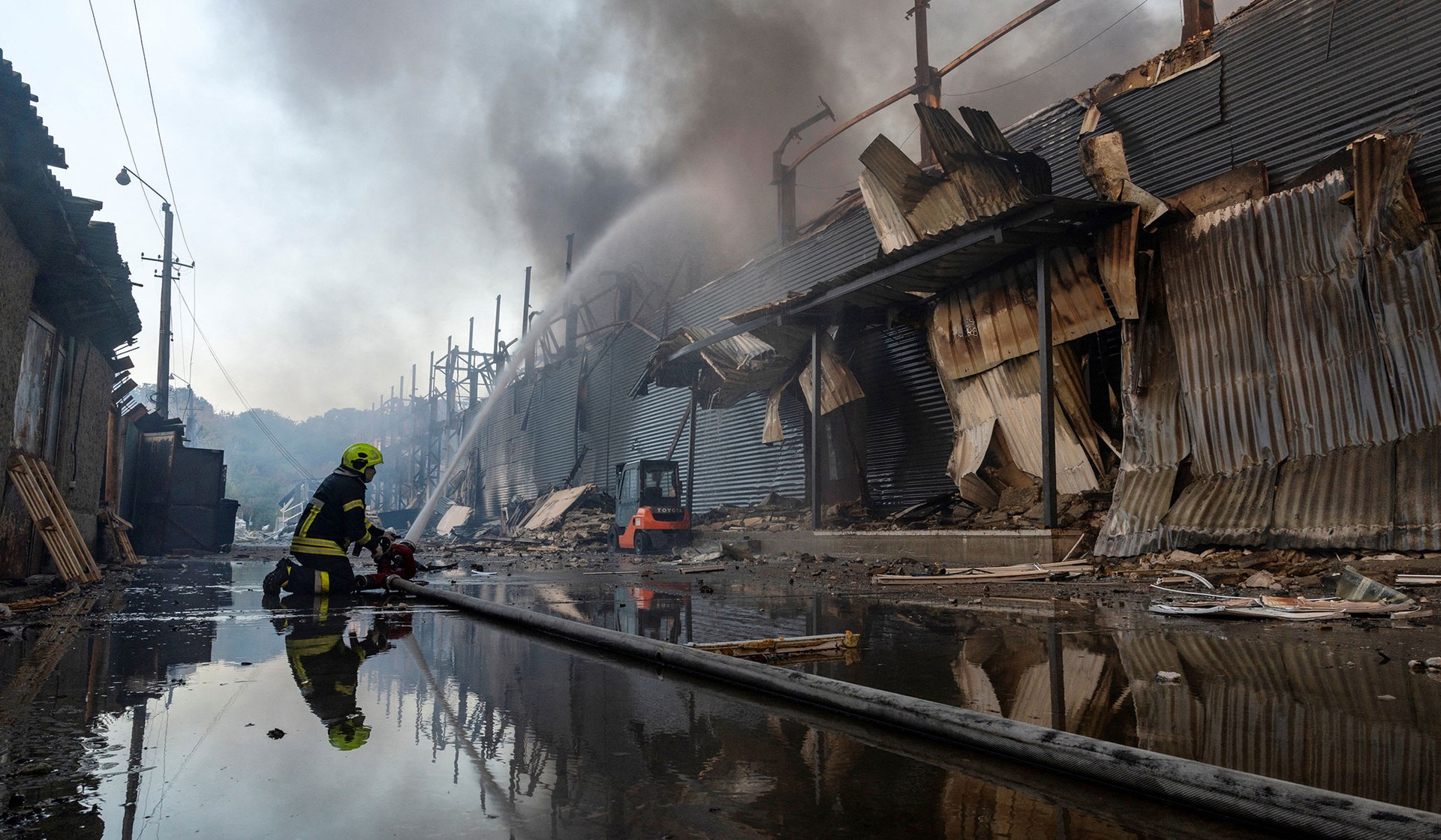 A firefighter works at the site of a warehouse that burned out after it was hit during a night of Russian missile attacks in Kyiv