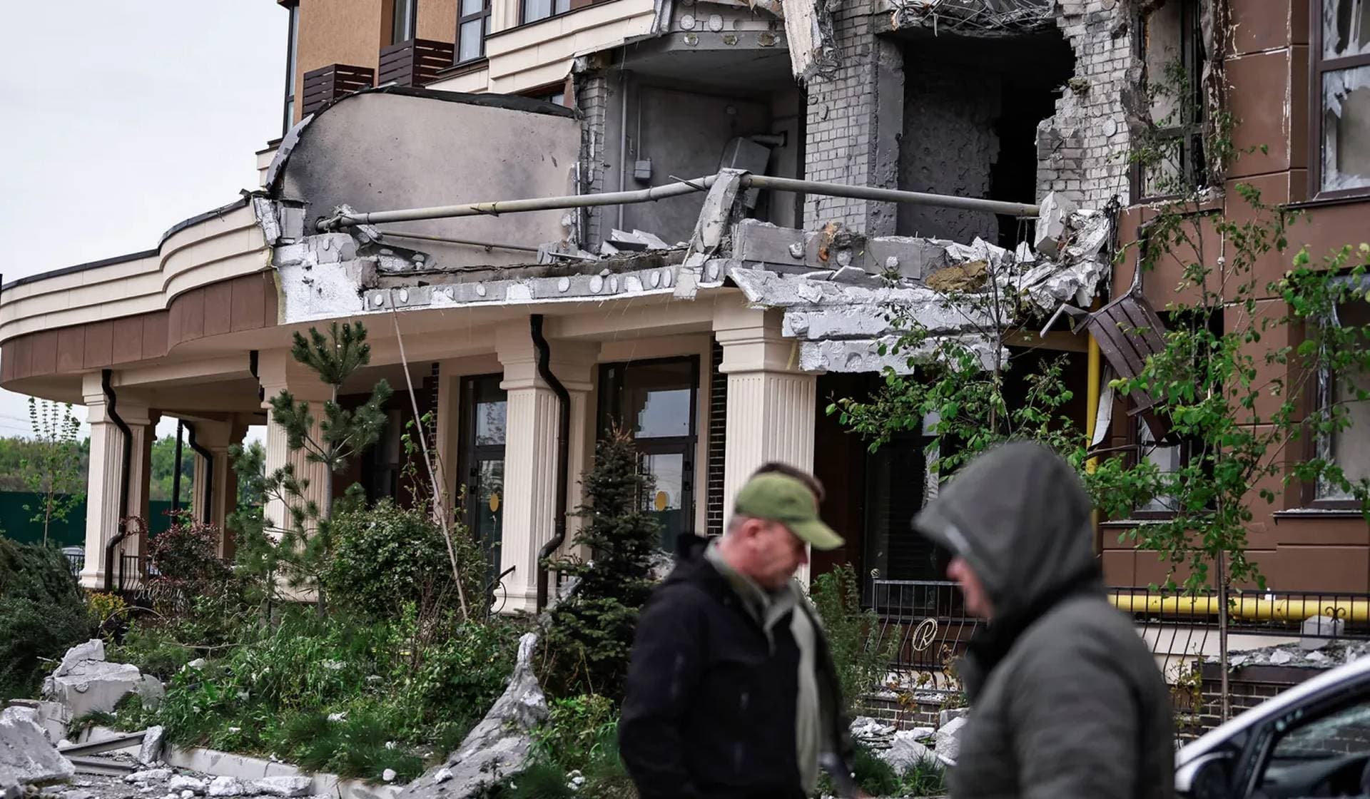 Residents walk near the building hit by a Russian drone strike on the outskirts of Kyiv