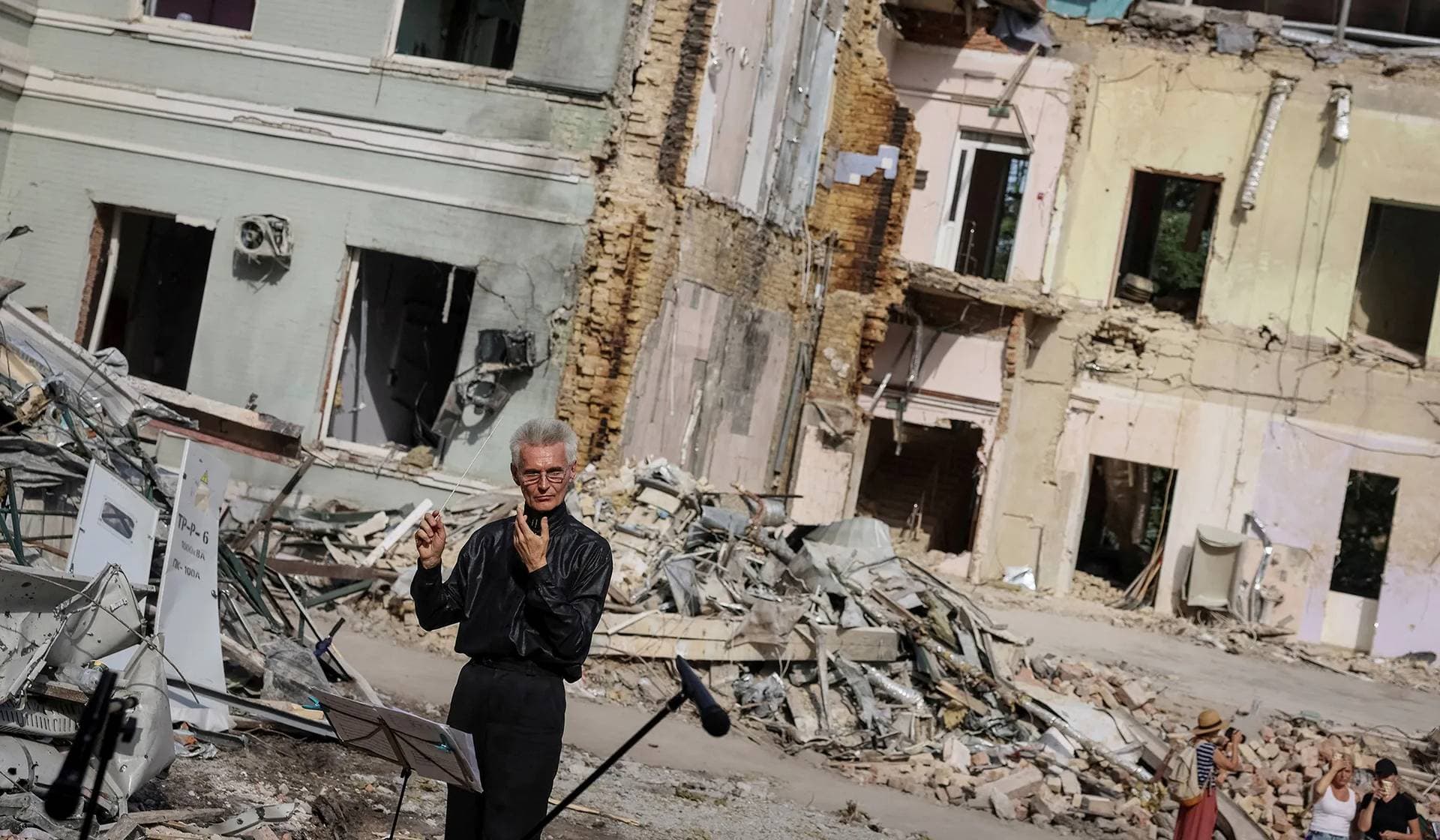 A conductor of the Kyiv Classic Orchestra conducts Requiem for the Dead at the ruins of Okhmatdyt Children's Hospital that was recently hit by a Russian missile, in Kyiv