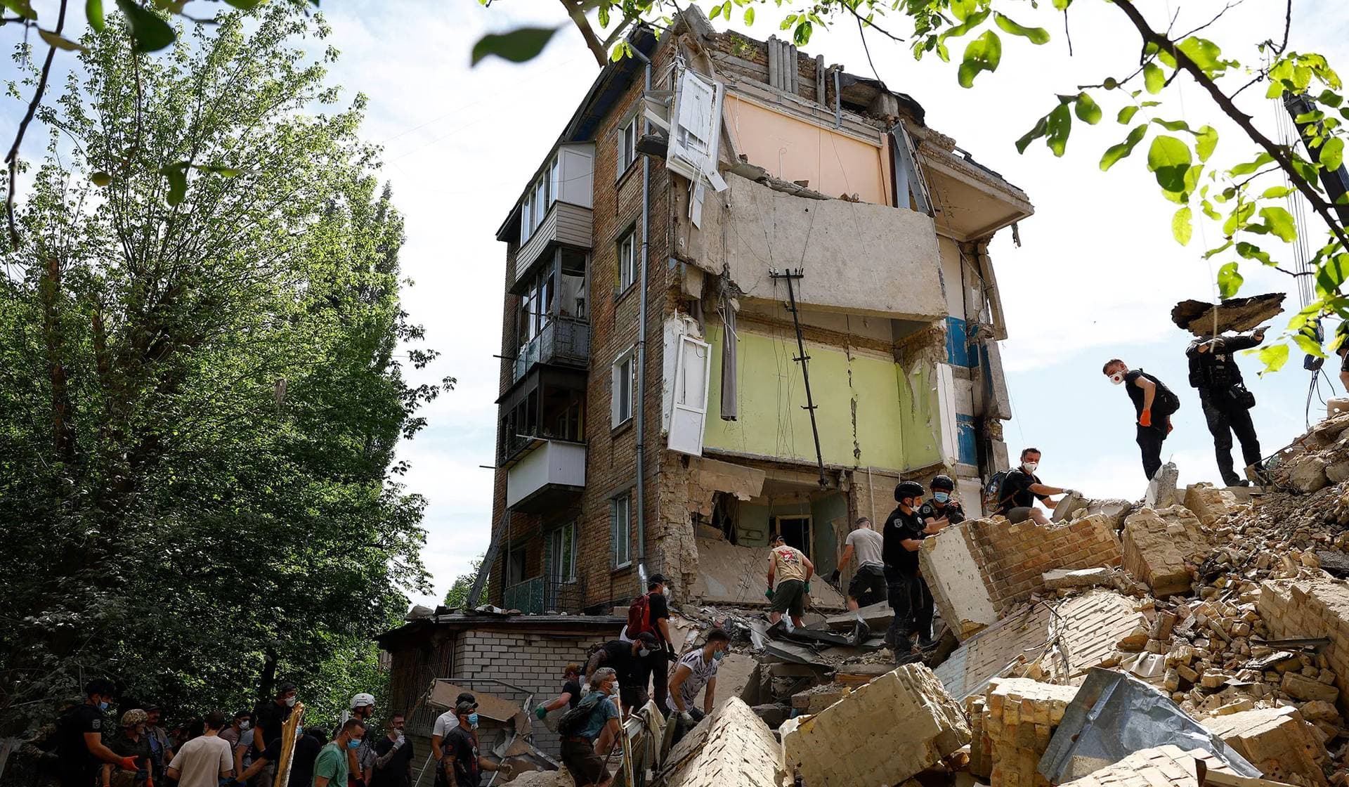 Local residents help rescuers to remove debris at an apartment building damaged during Russian missile strikes in Kyiv