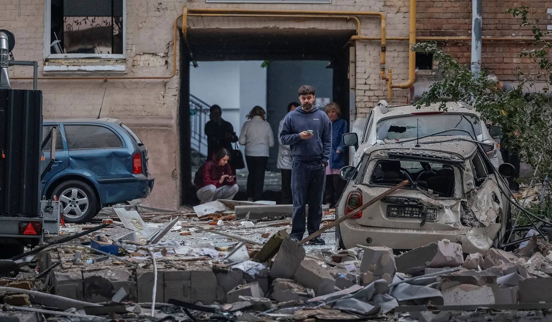 People gather at the site of buildings hit by Russian missile and drone strikes in Kyiv