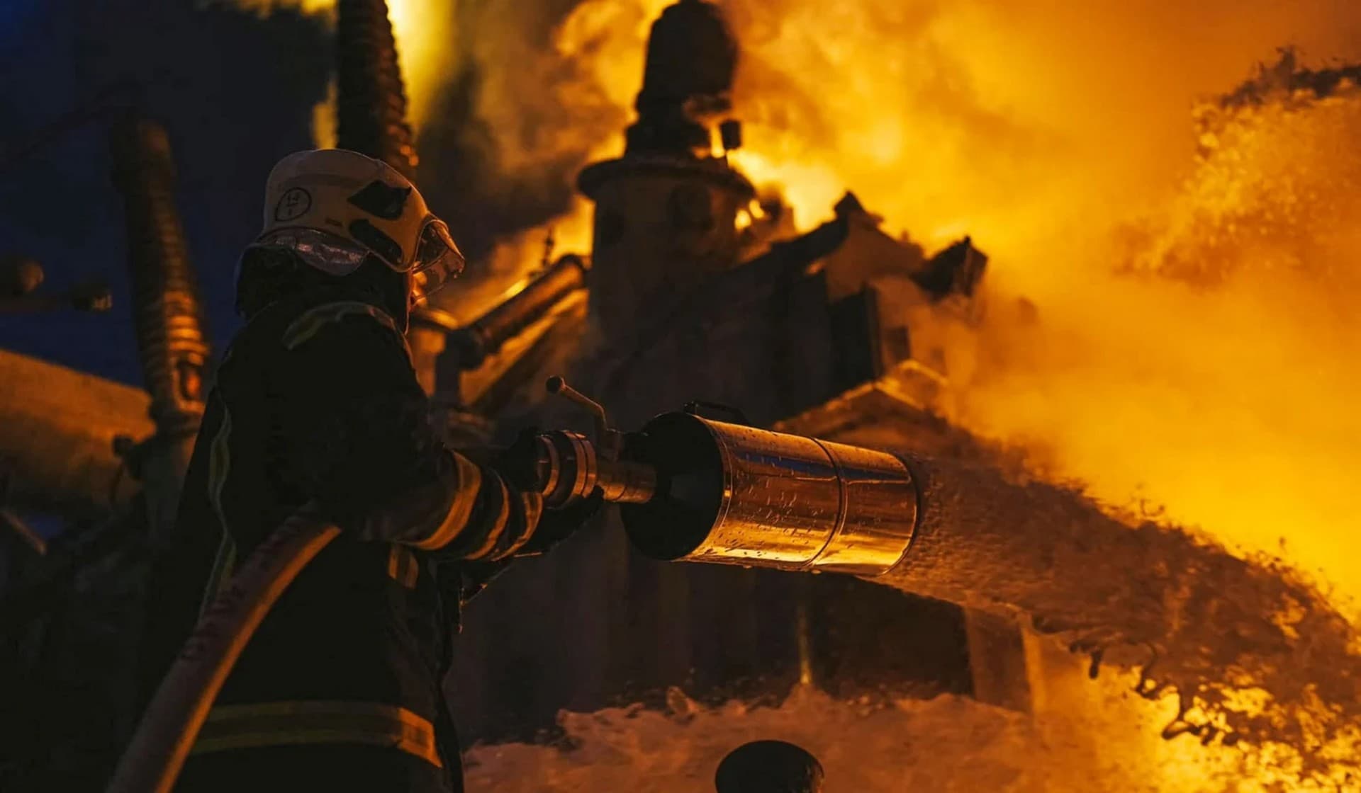 Firefighters work at a site of critical power infrastructure hit during Russia's drones attacks in Kyiv