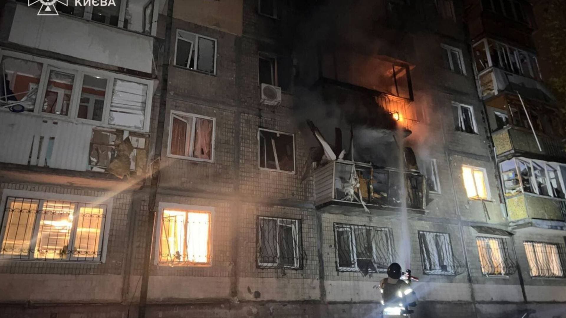 A firefighter works at a site of an apartment building hit by a Russian drone strike in Kyiv
