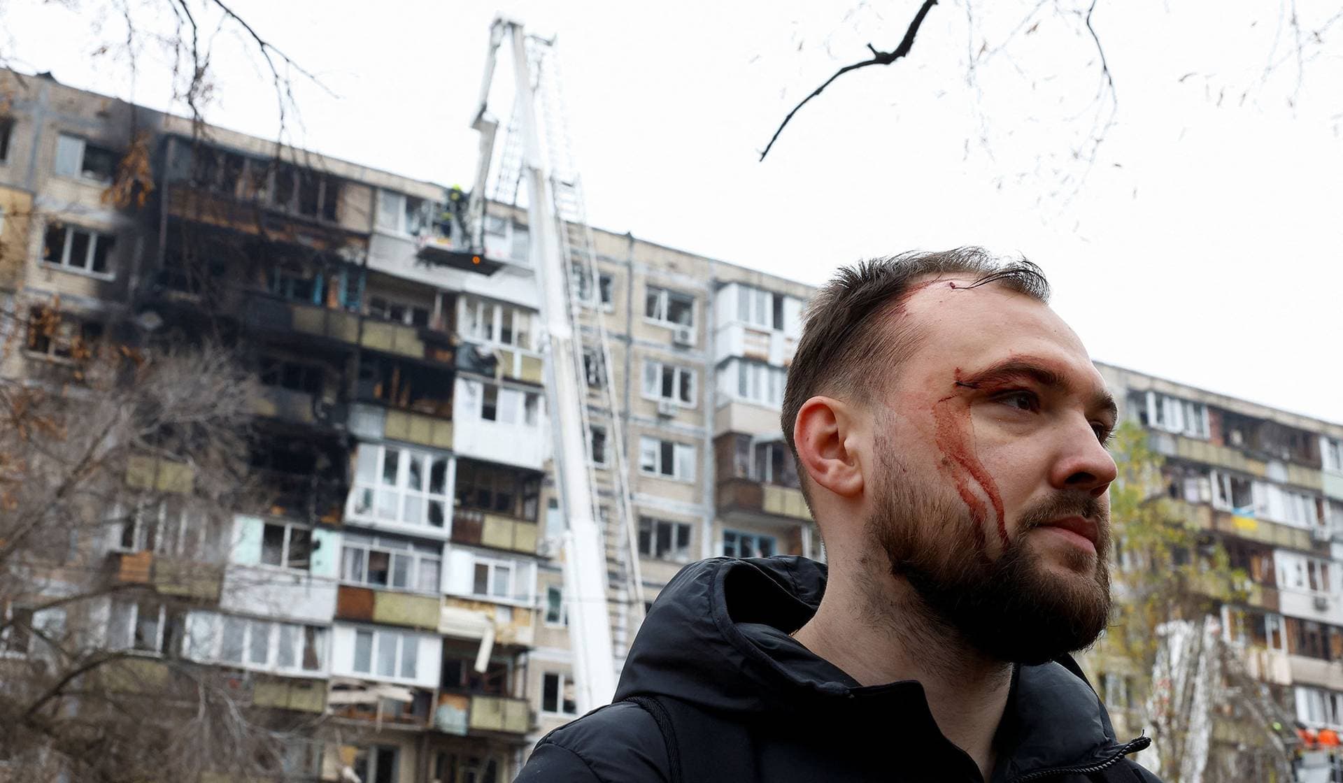 A resident stands near a damaged apartment building in the aftermath of a Russian missile and drone attack on Kyiv