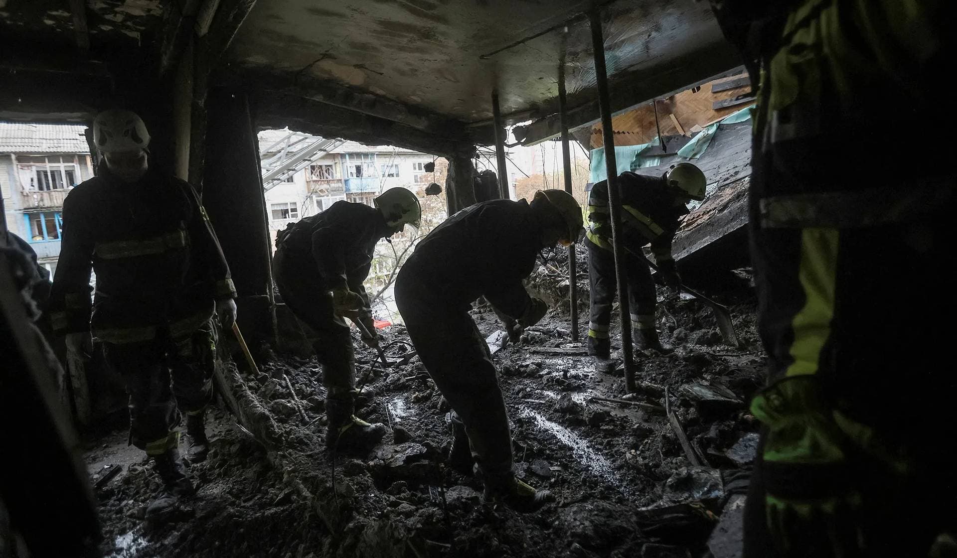 Firefighters work at the site of an apartment building damaged during a Russian drone and missile strike in Kyiv