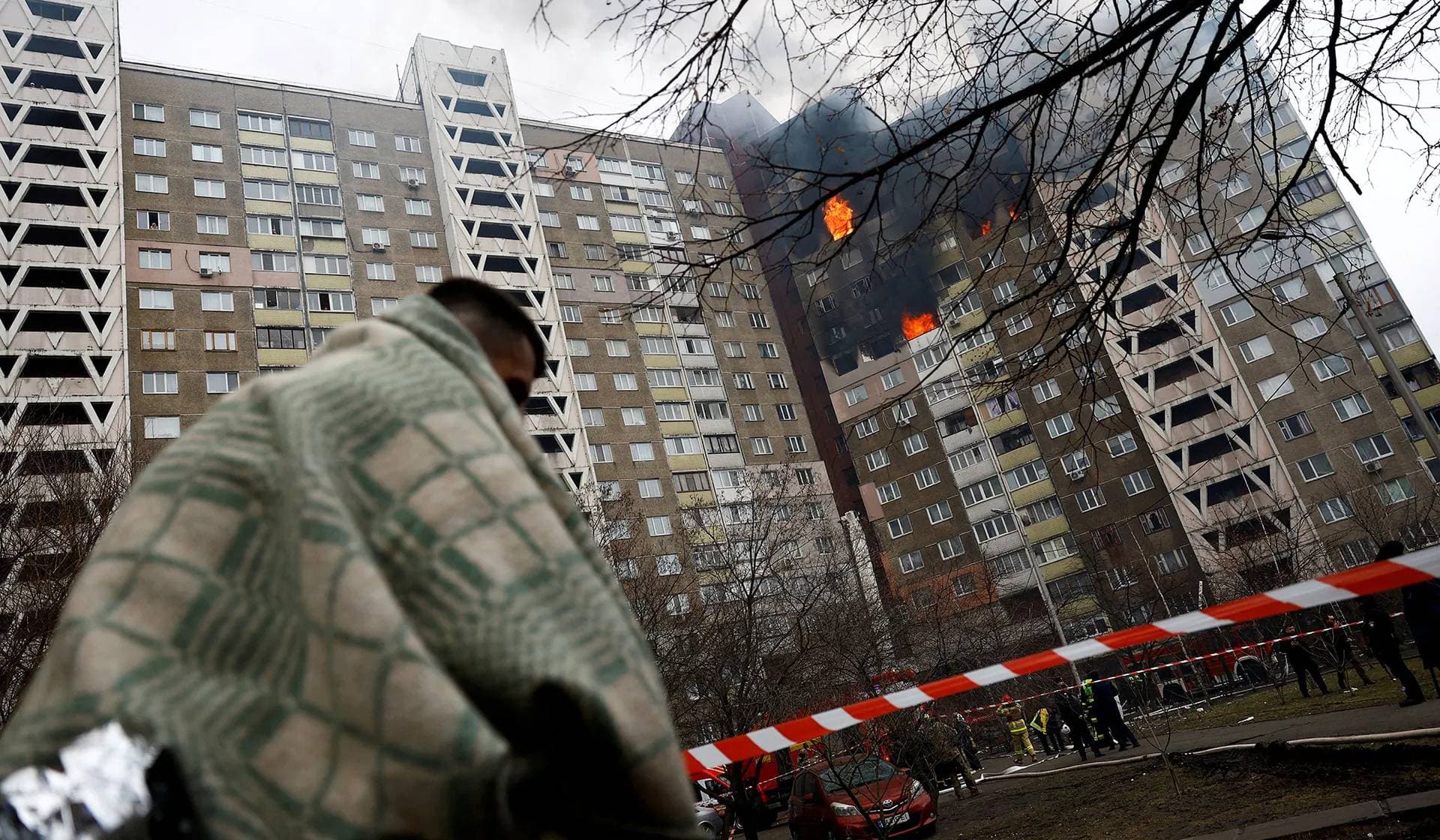 A person stands outside a cordoned-off area of a building damaged during a Russian missile strike in Kyiv