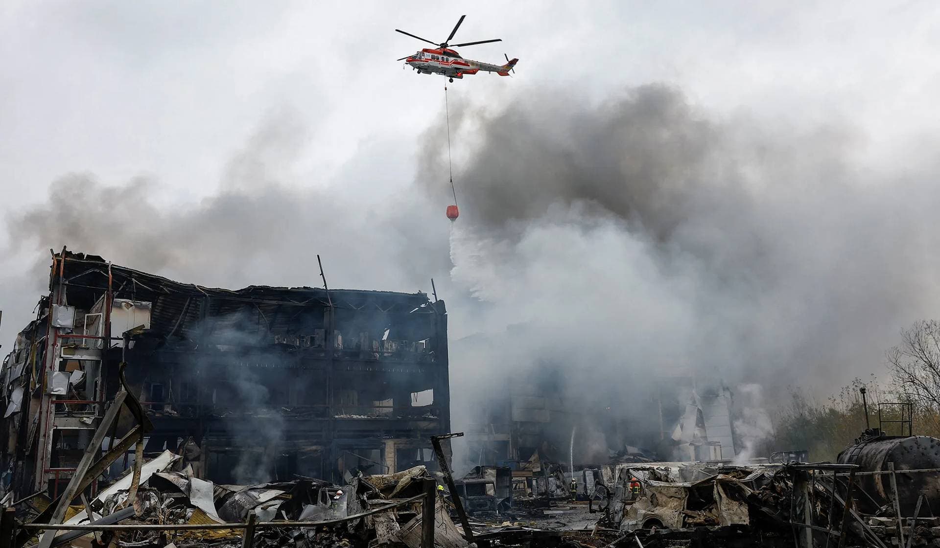 A firefighting helicopter drops water over food warehouses hit by an overnight Russian missile strike in Kyiv