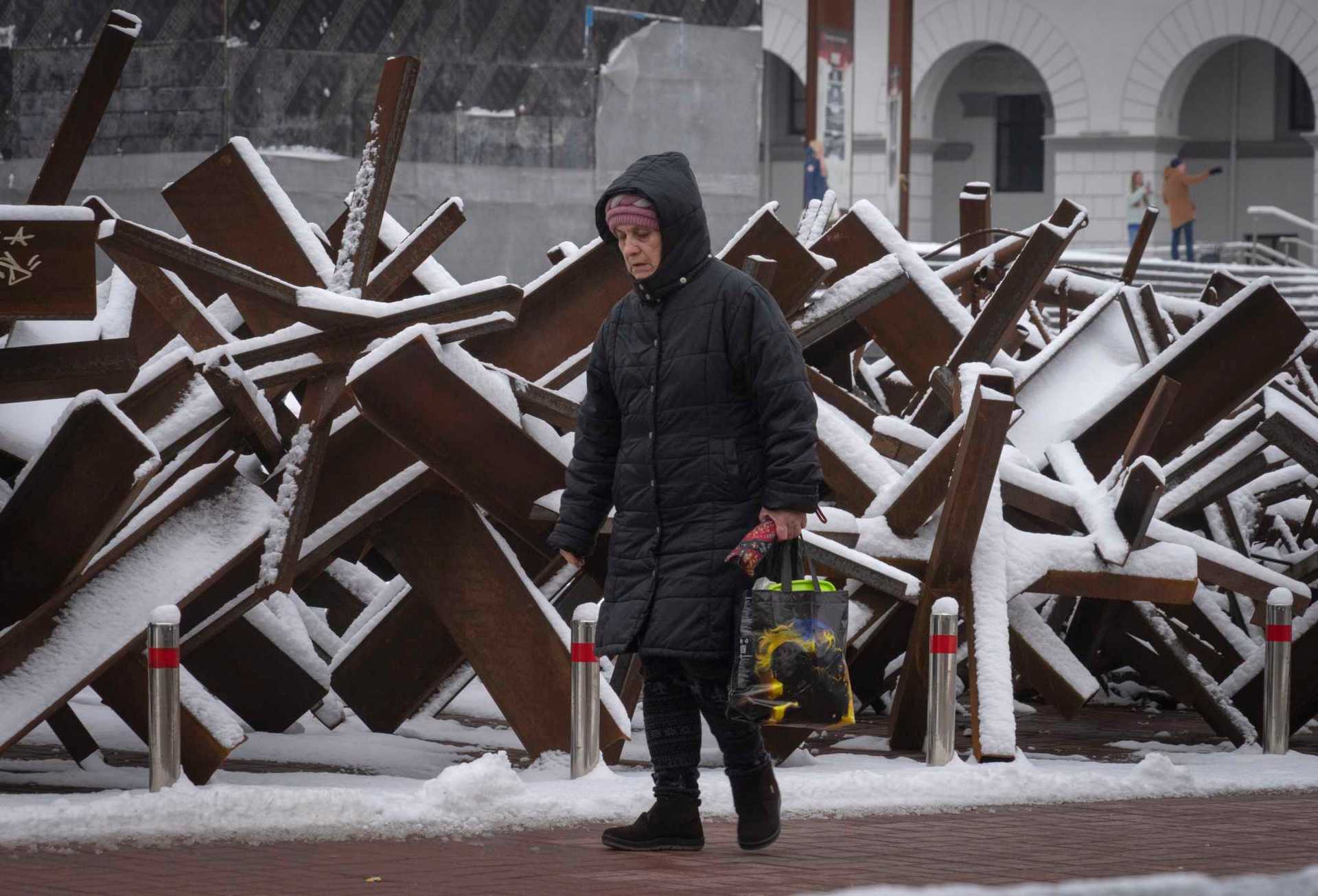 A woman passes by anti-tank hedgehogs in central Kyiv