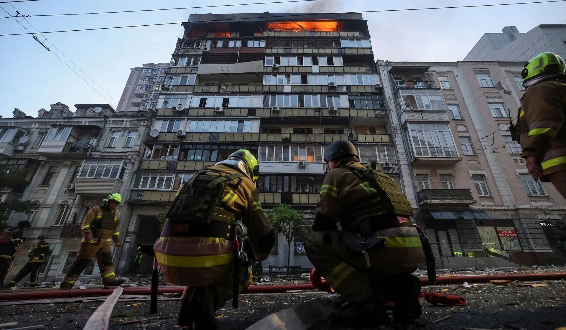 Firefighters work at the site of the apartment building hit by Russian drone strike in Kyiv