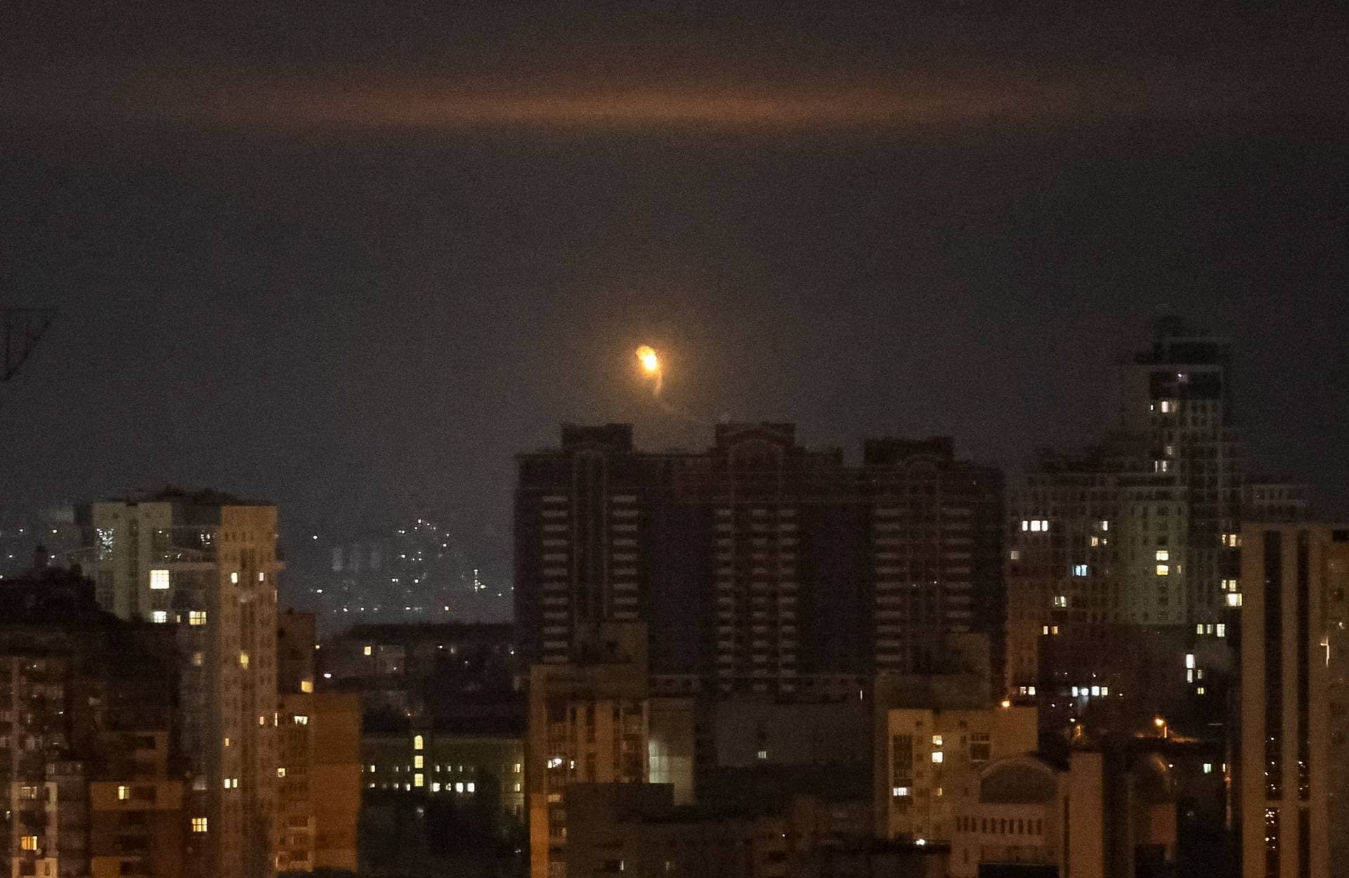 An explosion of a drone is seen in the sky over the city during a Russian drone strike in Kyiv