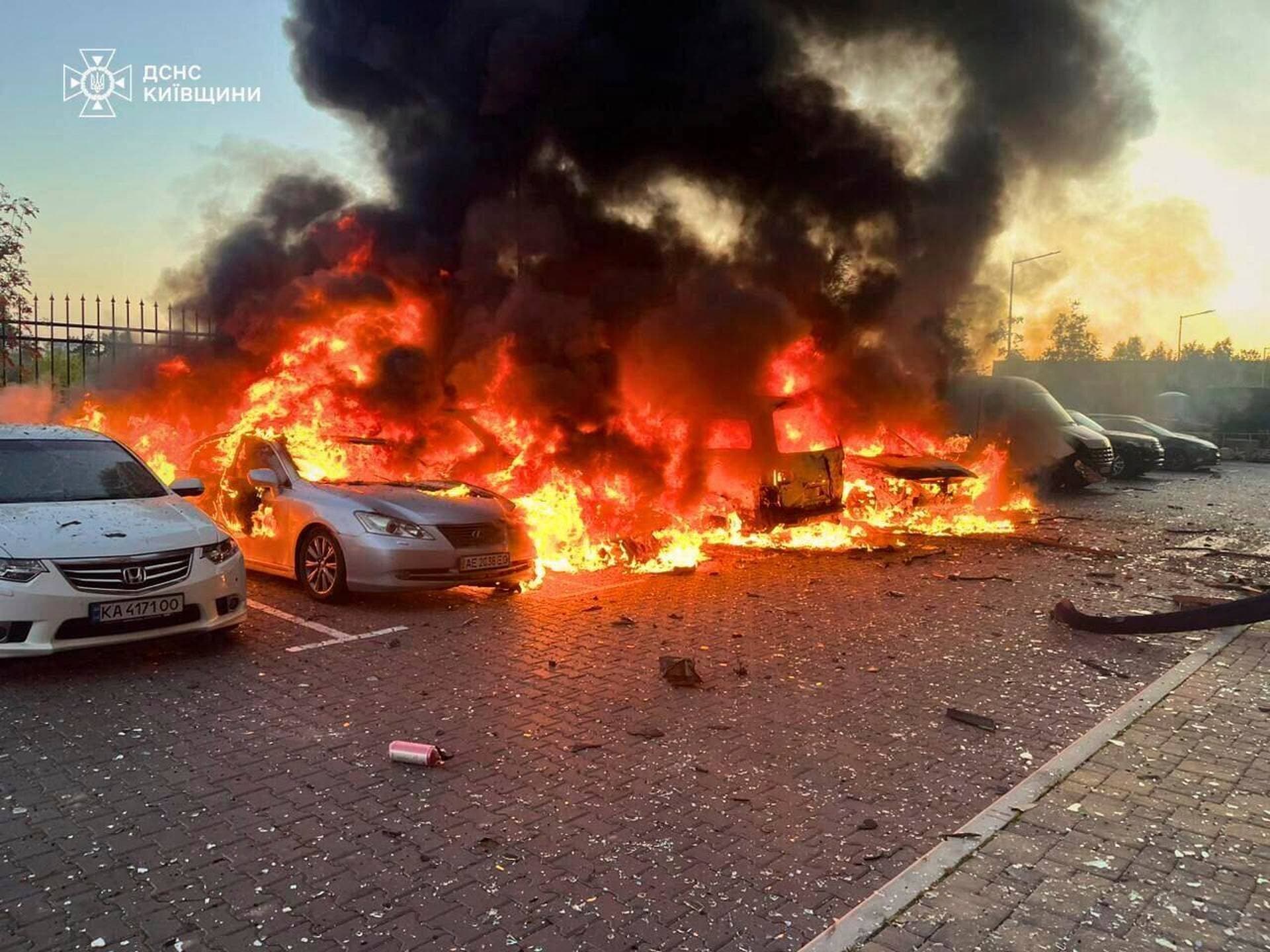 Cars on fire at the site of a residential building damaged during a Russian drone strike in outskirts of Kyiv