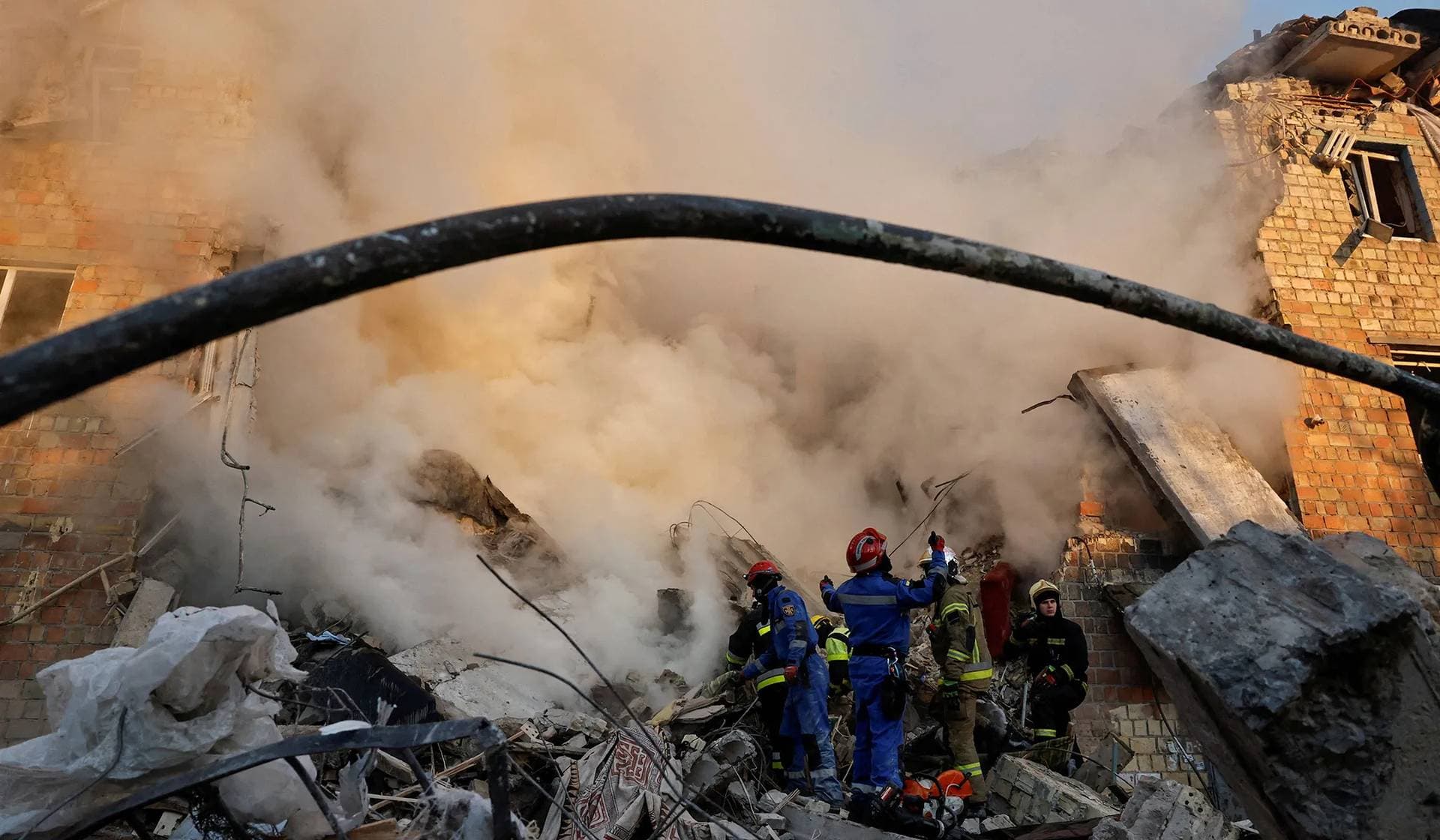 Rescuers work at the site of a building which was hit by Russian missile and drone strikes in Kyiv