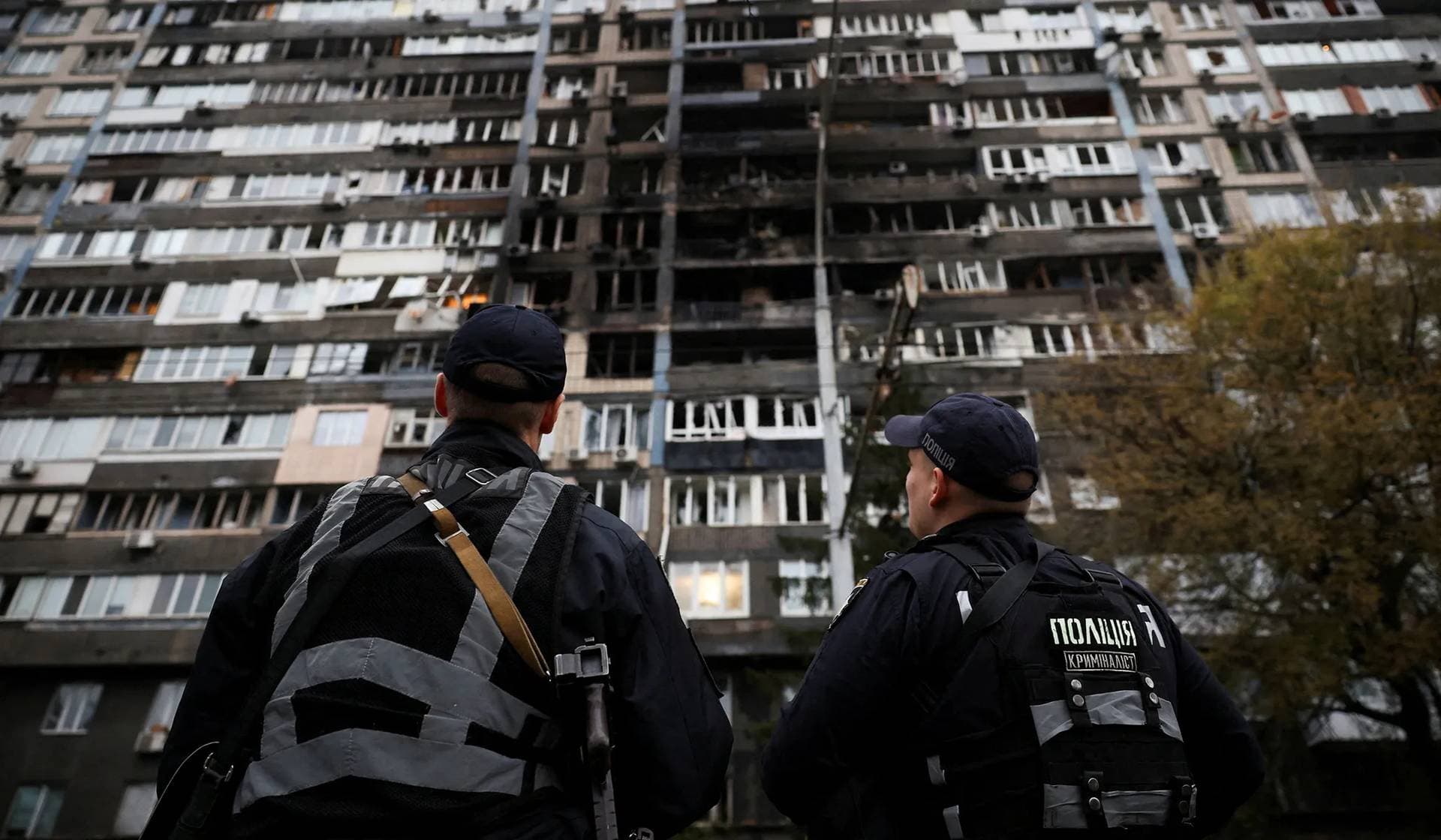 Police investigators look at an apartment building that was damaged during a Russian drone and missile strike in Kyiv