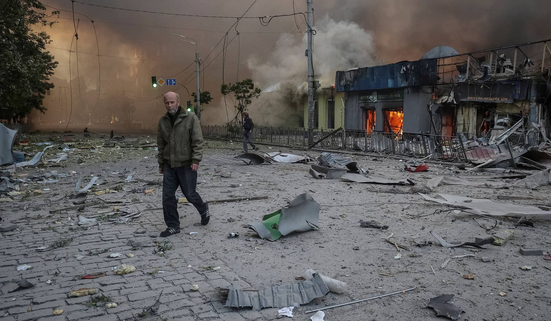 A resident walks at the site of a Russian missile and drone strike in Kyiv
