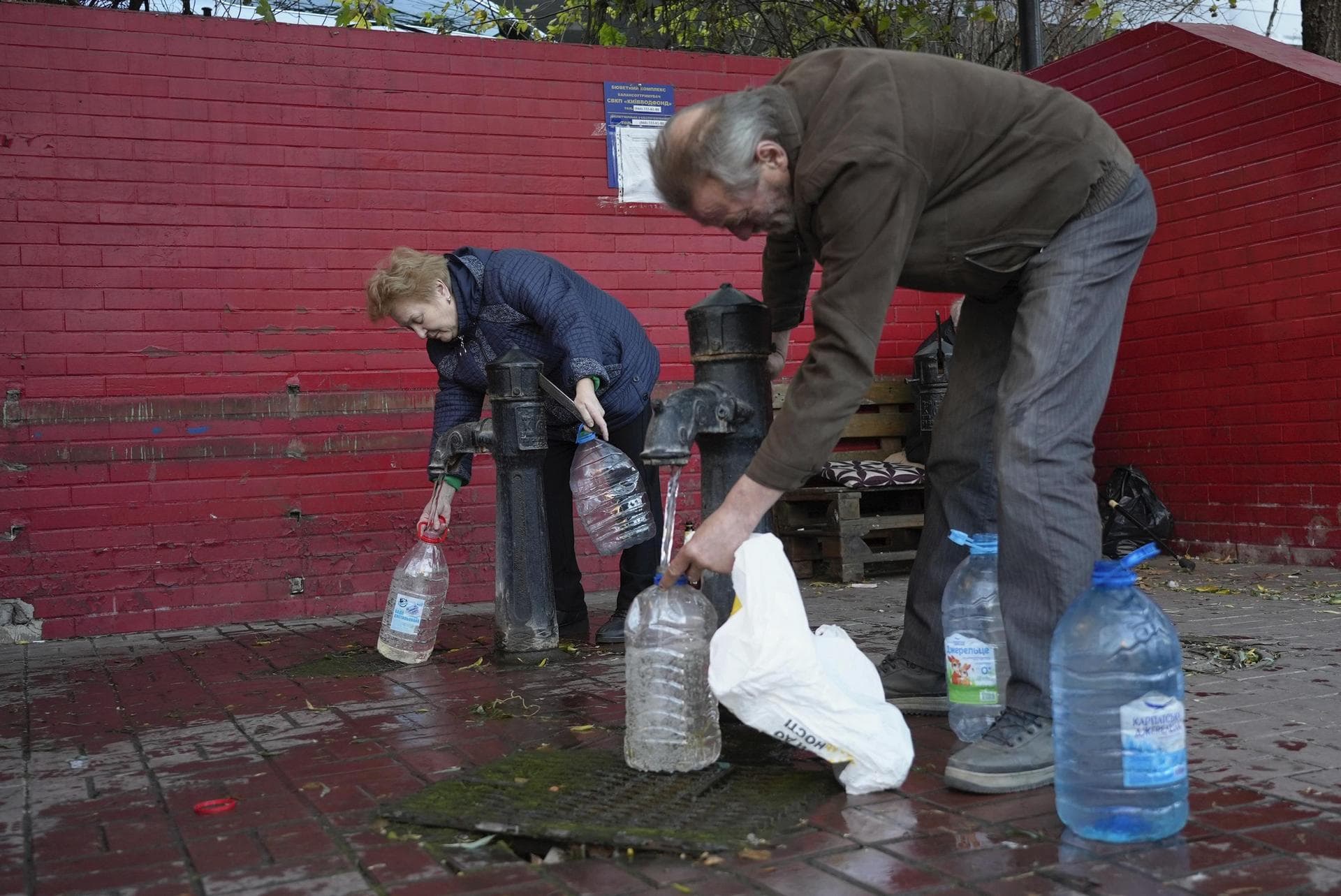 People fill containers with water from public water pumps in Kyiv