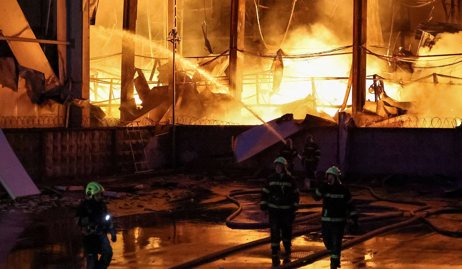 Firefighters work at the site of food warehouses hit by an overnight Russian missile strike in Kyiv
