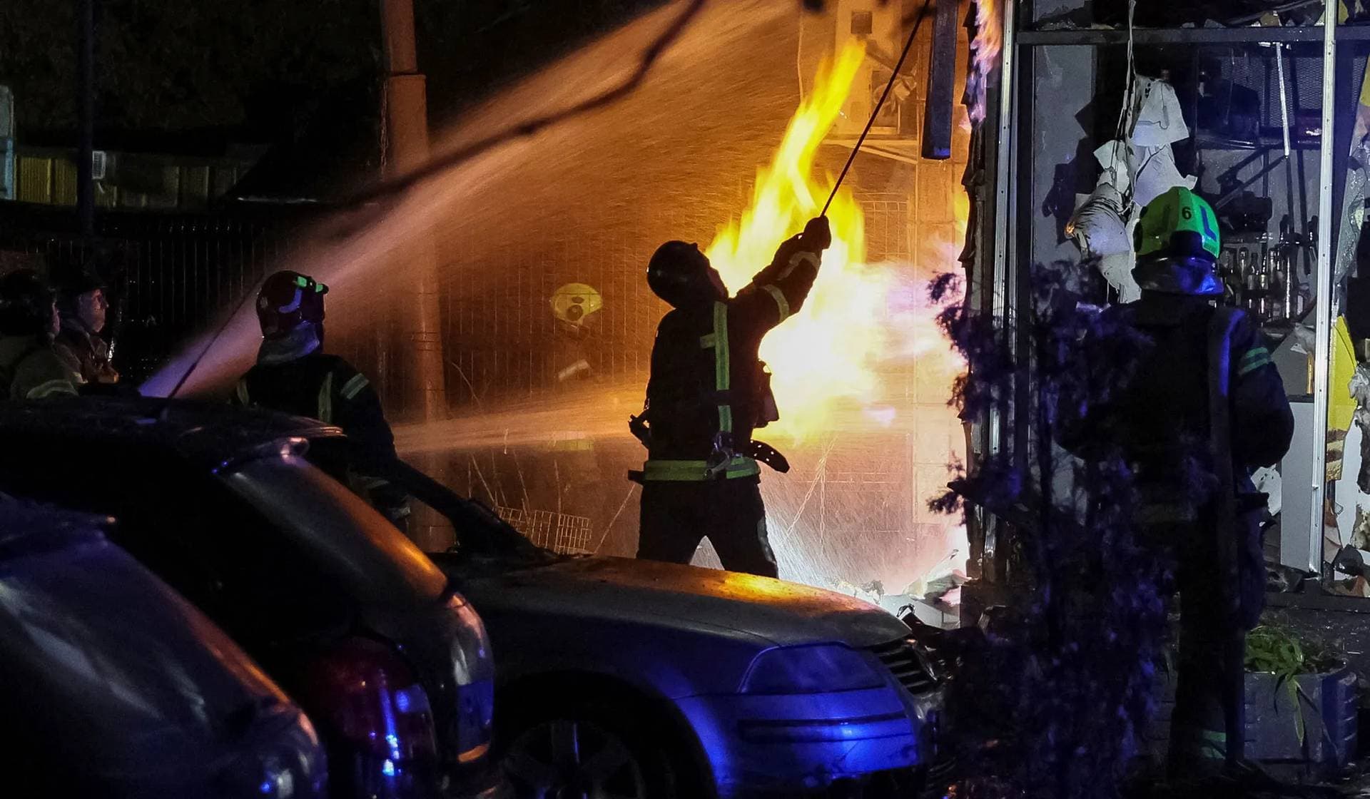 Firefighters work at a site of an apartment building hit by a Russian drone strike in Kyiv