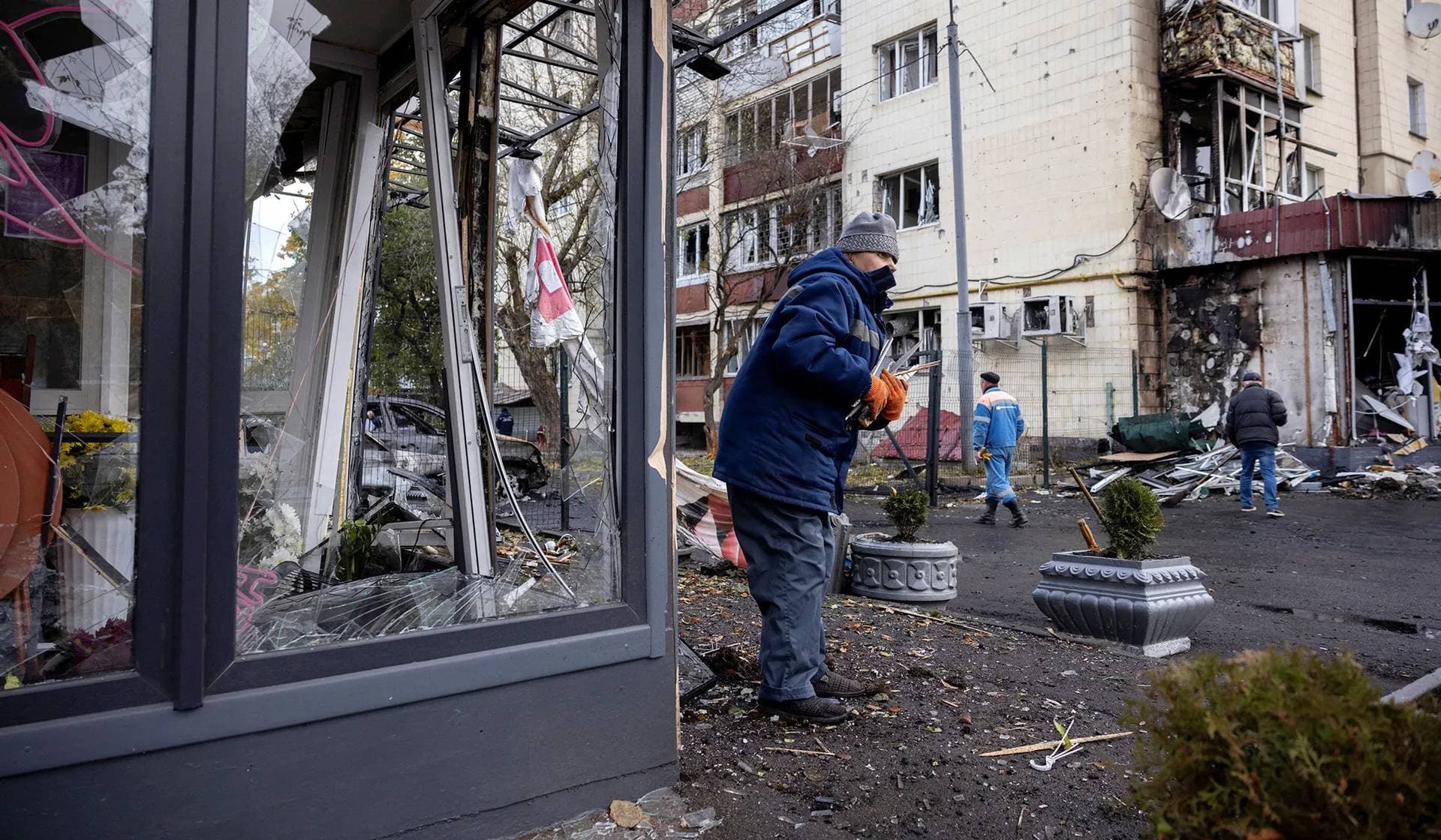 Workers remove debris from an apartment building damaged during a Russian drone strike in Kyiv