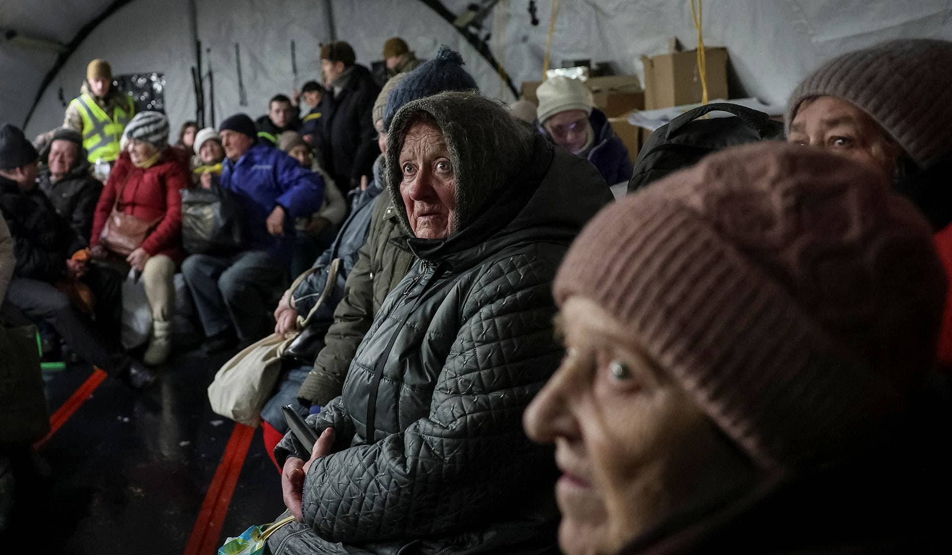 Residents wait for hot meals inside a tent at a government-run humanitarian aid point in Kyiv