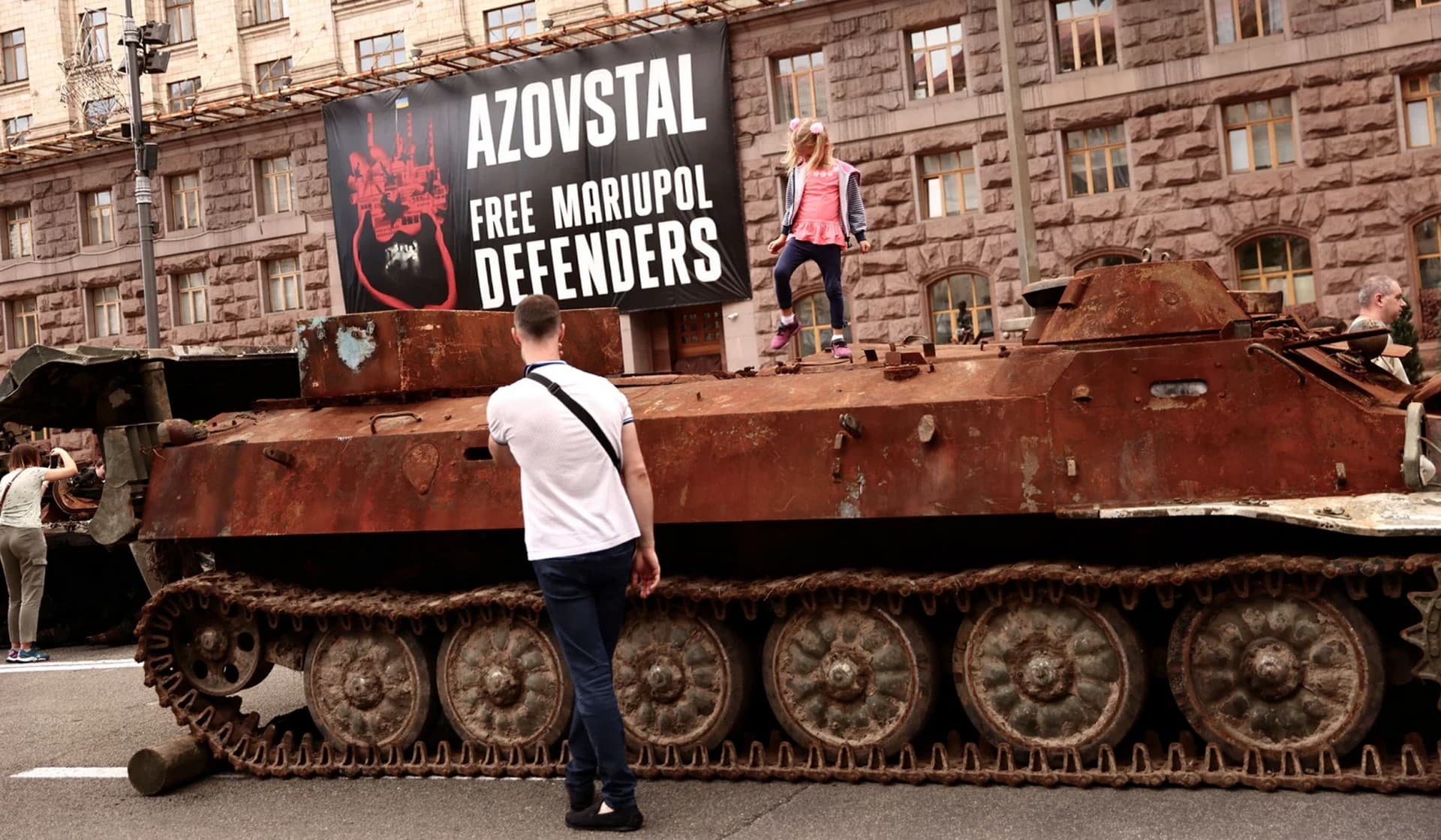 A child stands on a destroyed tank during an exhibition displaying destroyed Russian military vehicles in Kyiv