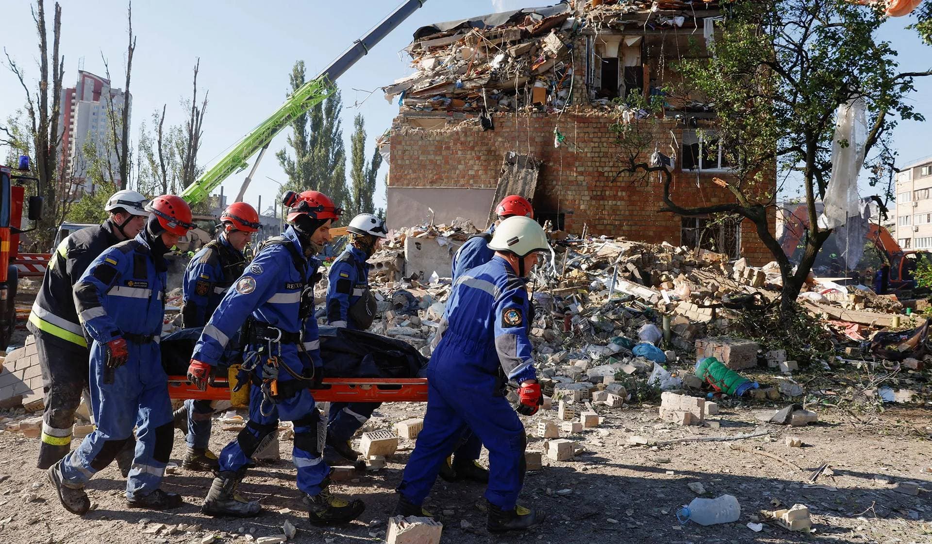 Rescuers carry a casualty at the site of a building which was hit by a Russian missile and drone strikes in Kyiv