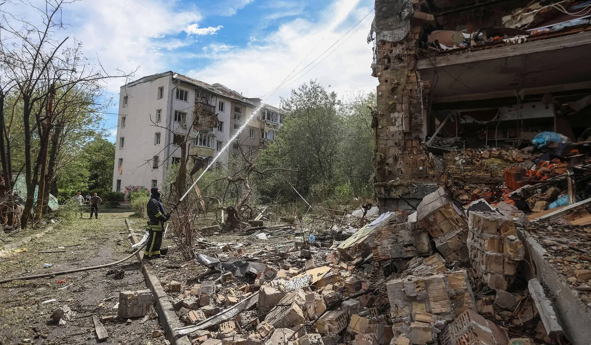 Firefighters work at an apartment building hit by a Russian missile strike in Kyiv