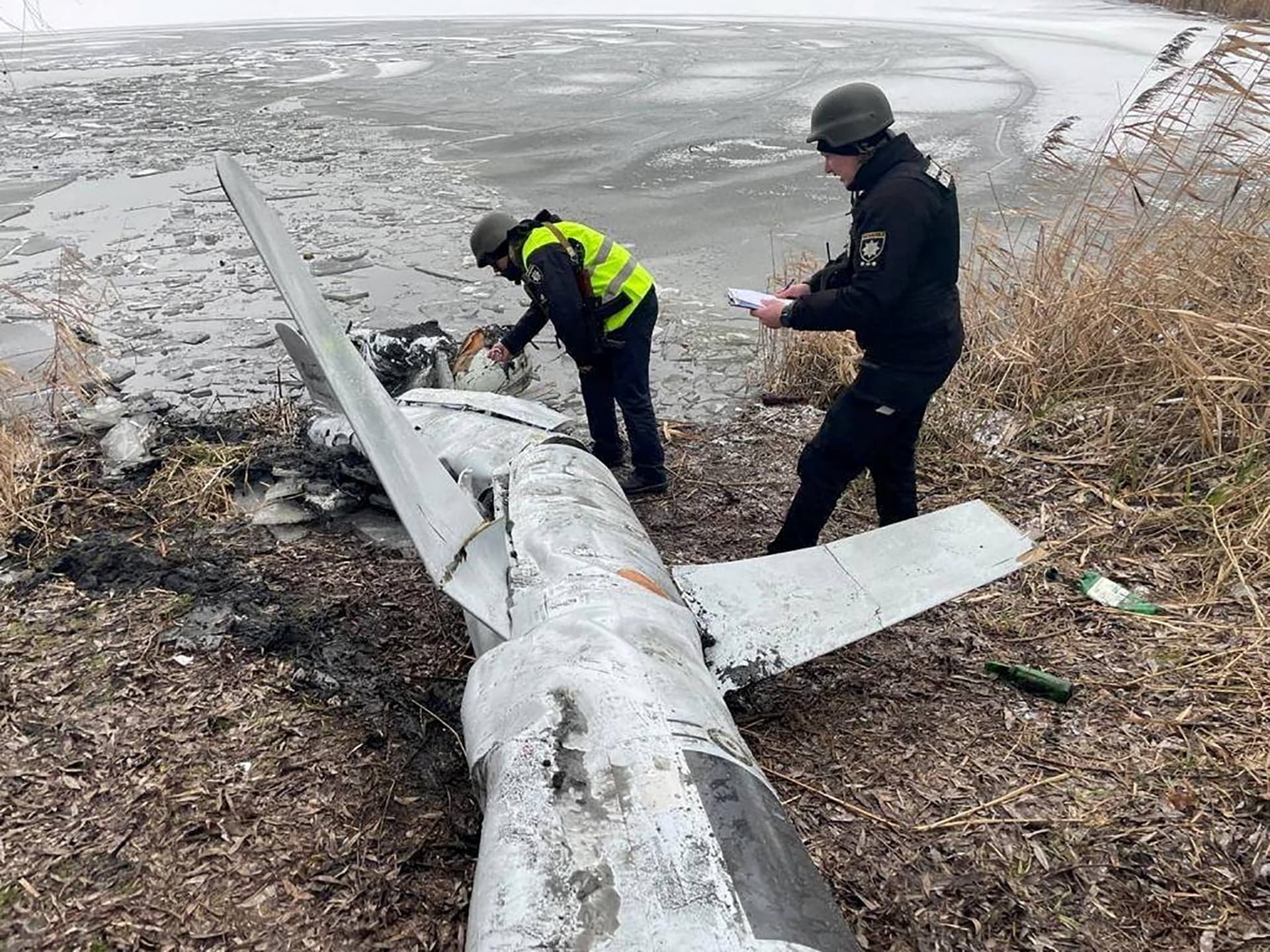 Police officers inspect a Russian cruise missile shot down by the Ukrainian Air Defence Forces in Kyiv Region