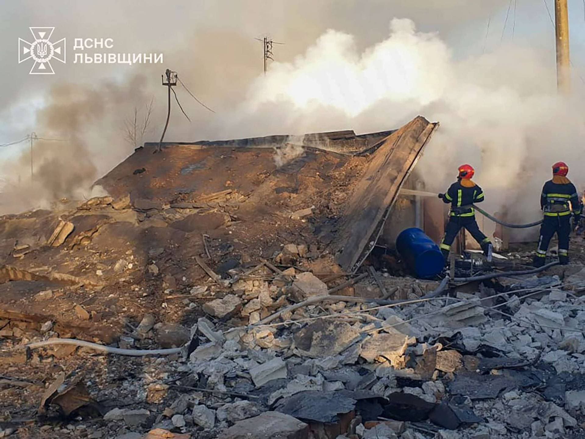 Firefighters work at the site of a residential area hit by a Russian missile strike in Lviv region