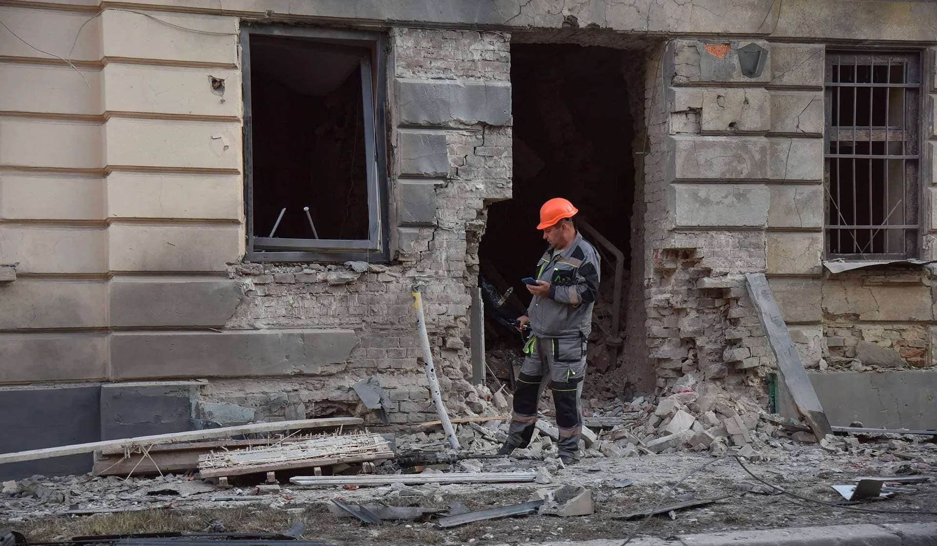 A municipal employee checks the site of an apartment building damaged during Russian drone and missile strikes in Lviv