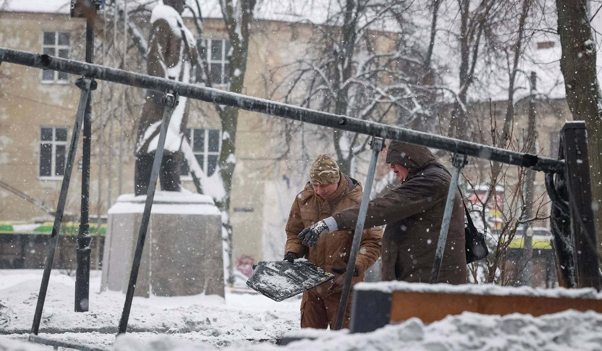 Experts work at the site of a Russian drone strike near the statue of Stepan Bandera in Lviv