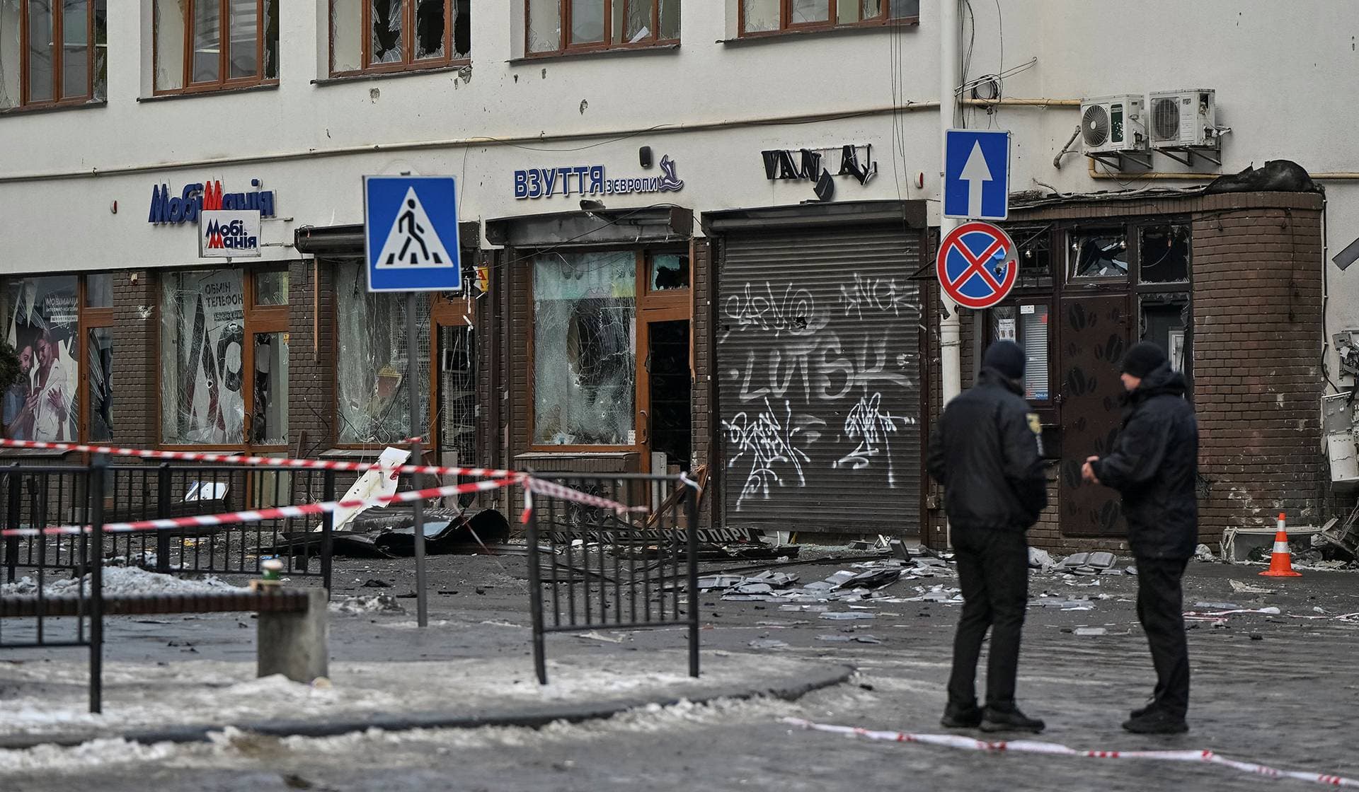 People stand at the site of explosions in the city's downtown in Lviv
