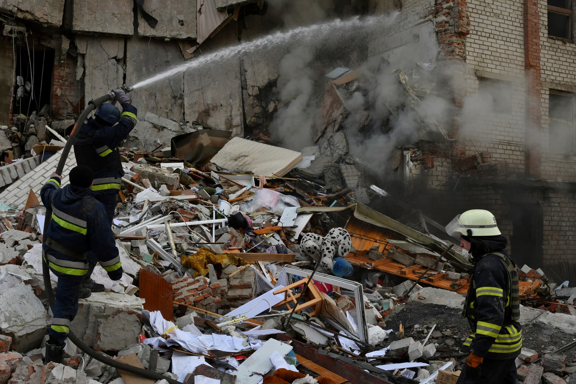 Firefighters work at the scene of a damaged residential building after Russian shelling in the liberated Lyman