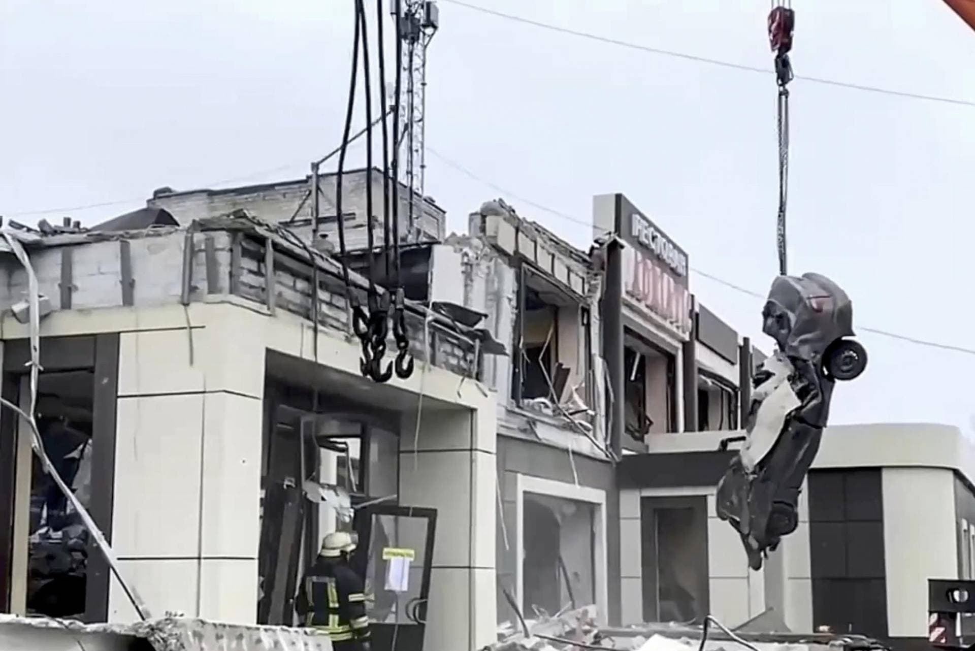 Local residents stand next to the debris of a destroyed building in Lysychansk