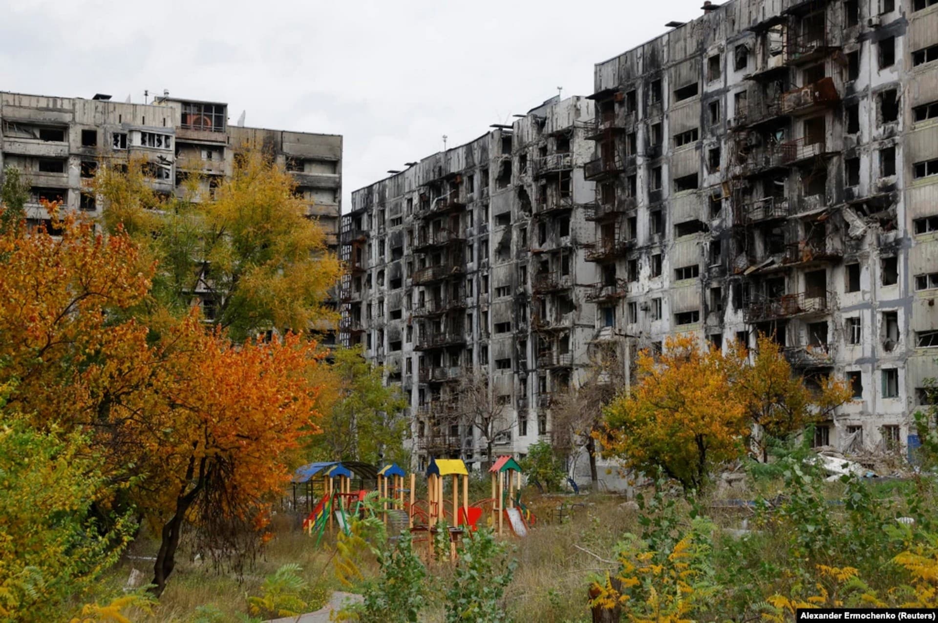 A child's playground in the courtyard of a ruined apartment block in Mariupol